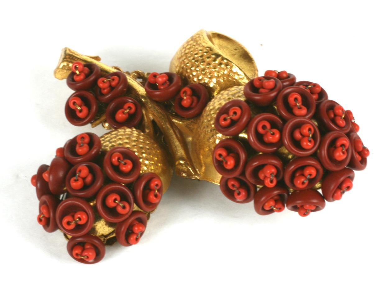 Unusual Miriam Haskell acorn branch cluster brooch of signature Russian Gilt. The high relief acorn branch is hand sewn with  pate de verre sienna brown cups with coral seed bead centers. Mounted on a signature filigree backing.
Excellent Condition,
