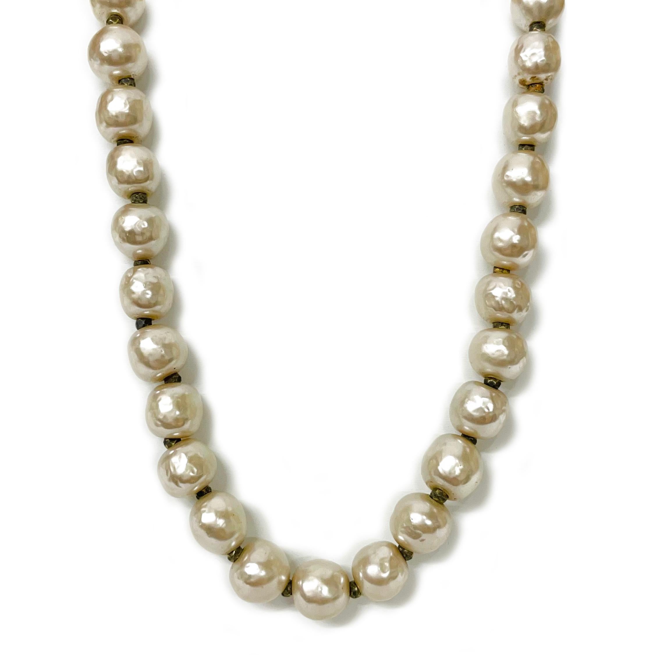 Miriam Haskell Baroque Faux Pearl Necklace. This vintage necklace features a single strand of Baroque faux pearls ranging in size from 8 - 9mm. The clasp has a round box closure and the designer's name Miriam Haskell on the clasp. Adorning the top