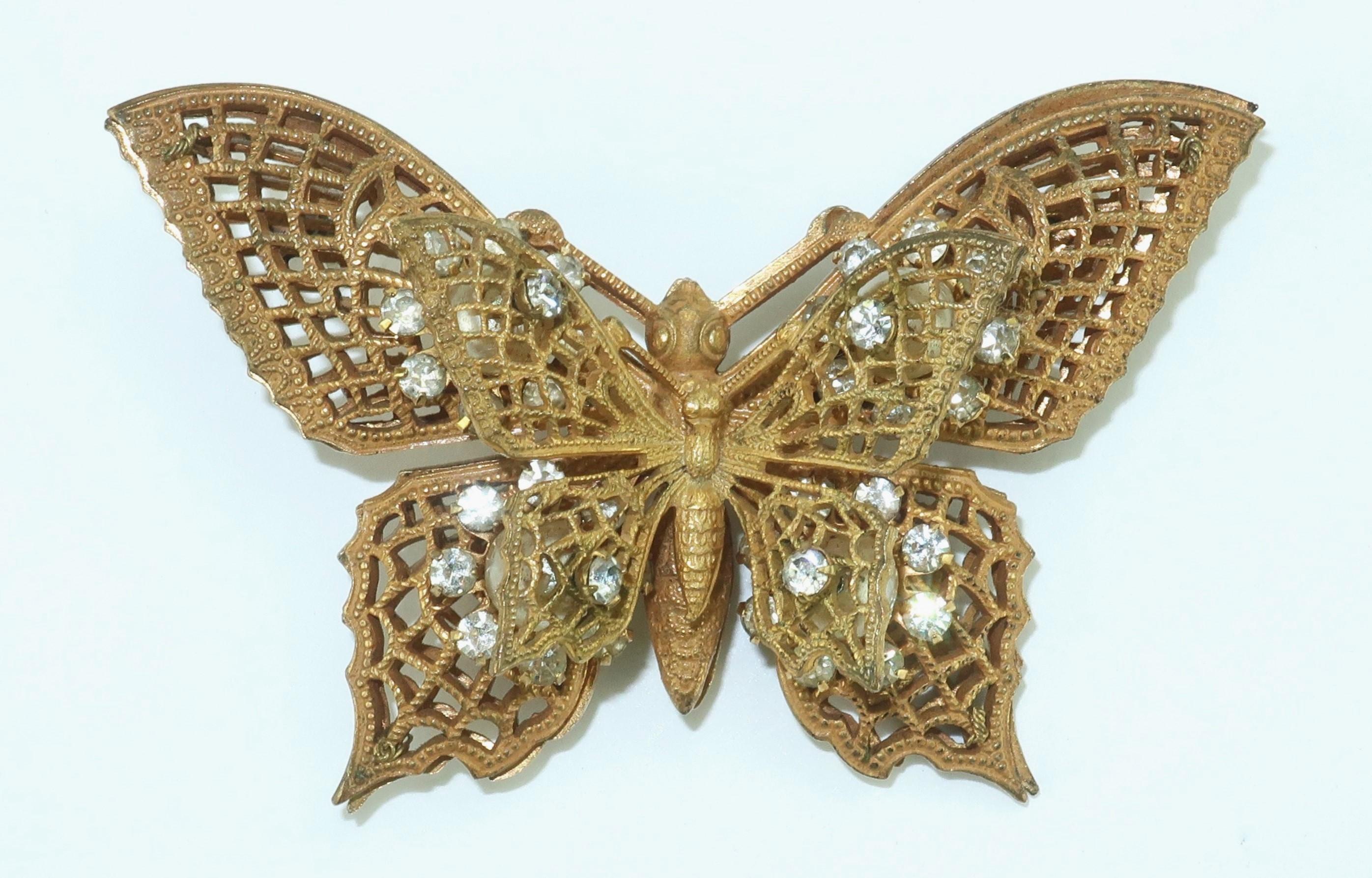Beautiful 1950's Miriam Haskell brooch in the form of a gilt metal butterfly embellished with baroque faux pearls and sparkling crystal rhinestones. The brooch is highly detailed with an ornate filigree typical of Ms. Haskell's designs including