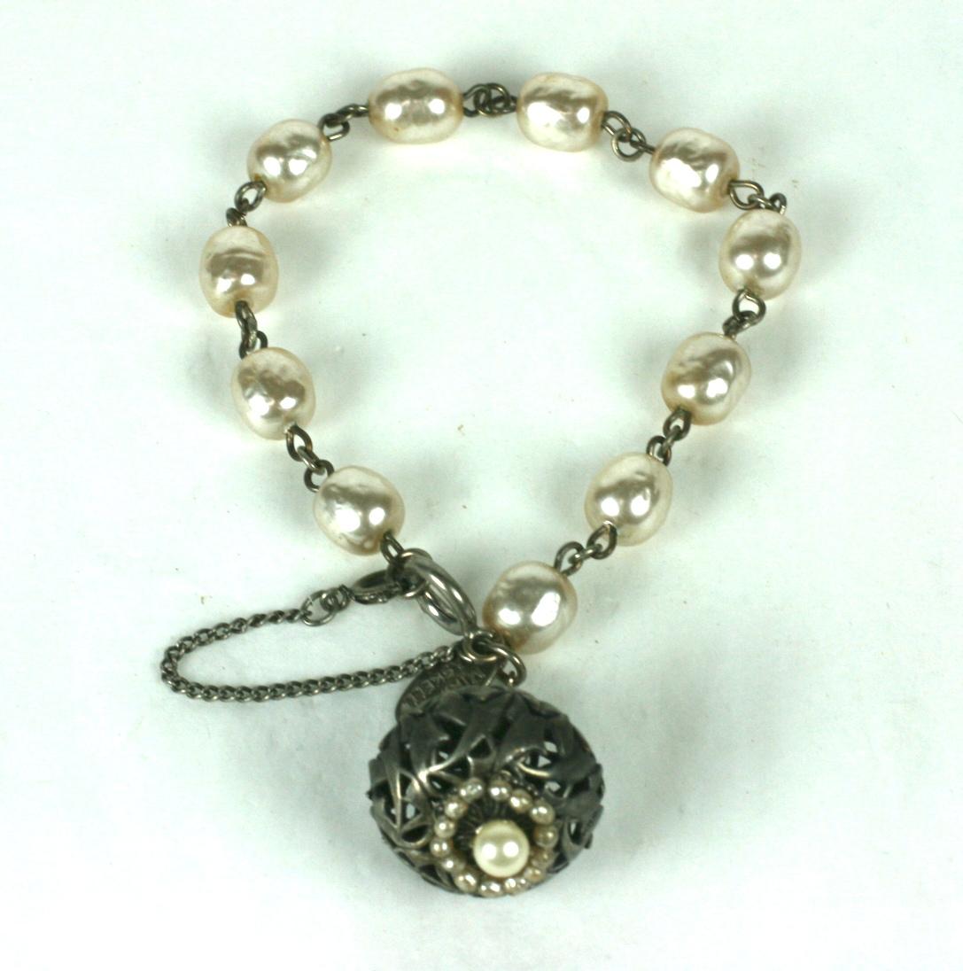 Miriam Haskell faux baroque pearl and antique silver gilt fob bracelet. Composed of signature faux baroque pearl links with a large pierced  antiqued silver gilt and baroque pearl charm.
The dangling lantern shape fob is decorated with hand sewn