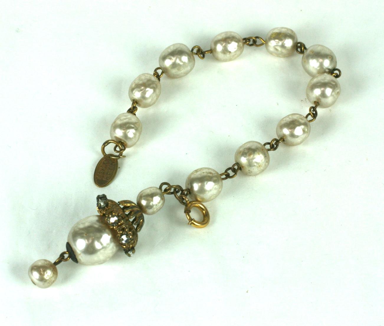 Miriam Haskell faux baroque pearl fob bracelet. Composed of signature baroque pearl links with a large baroque pearl and Russian gilt filigrees.  The dangling  lantern shape fob decorated with hand sewn round faceted round crystal rose