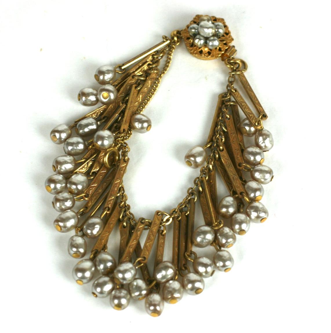 Bracelet à franges en fausses perles de Miriam Haskell, de style victorien, composé de perles baroques et de dorures russes.  des barres incisées créant une bordure de perles frangées. Fermoir hexagonal avec  détail de perles baroques.
Excellent