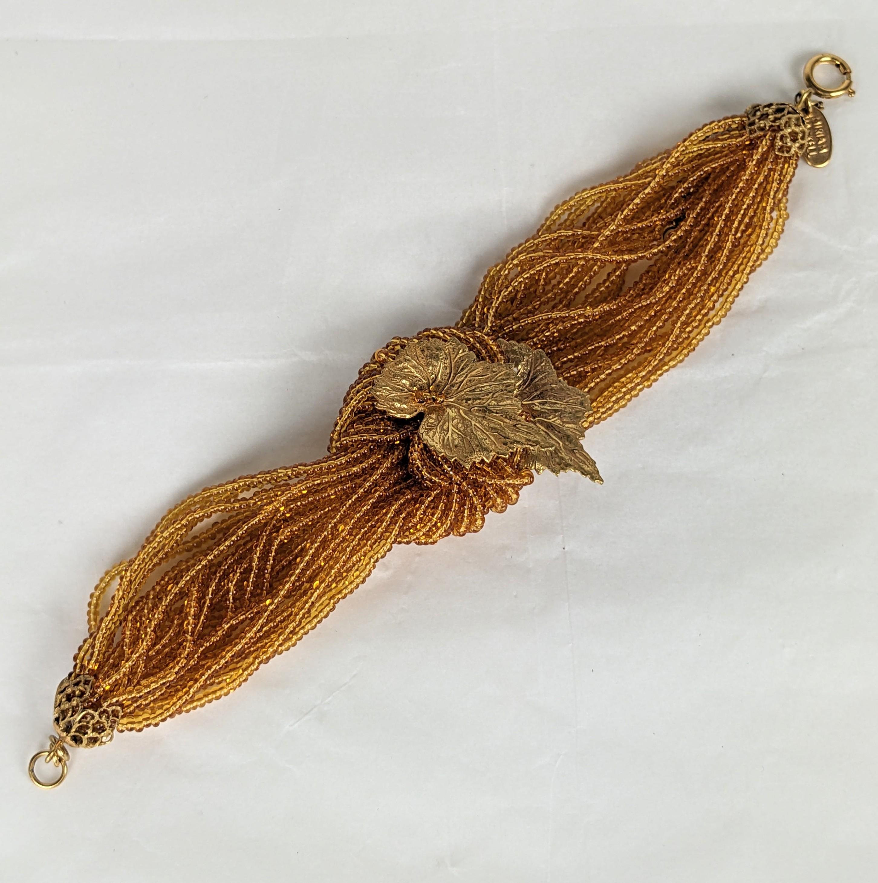Miriam Haskell Beaded Leaf Bracelet aus den 1980er Jahren. Stränge aus zitronengelben Glasperlen sind geknotet und mit vergoldeten Blättern besetzt. Signiert mit Anhänger, mit Sicherheitskette. 7.5