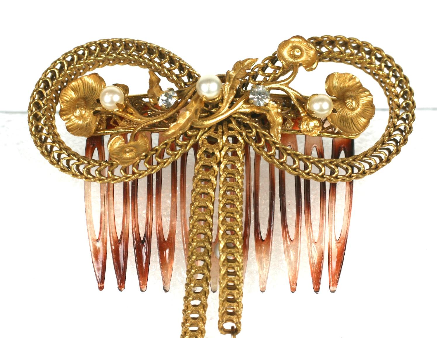 Miriam Haskell Victorian Revival hair comb.  Formed as a bow knot of signature Russian gilt box chain with floral branch filigrees and round pearls.
The bow ends further detailed by baroque dangling pearls with gilt caps. The comb is made of faux