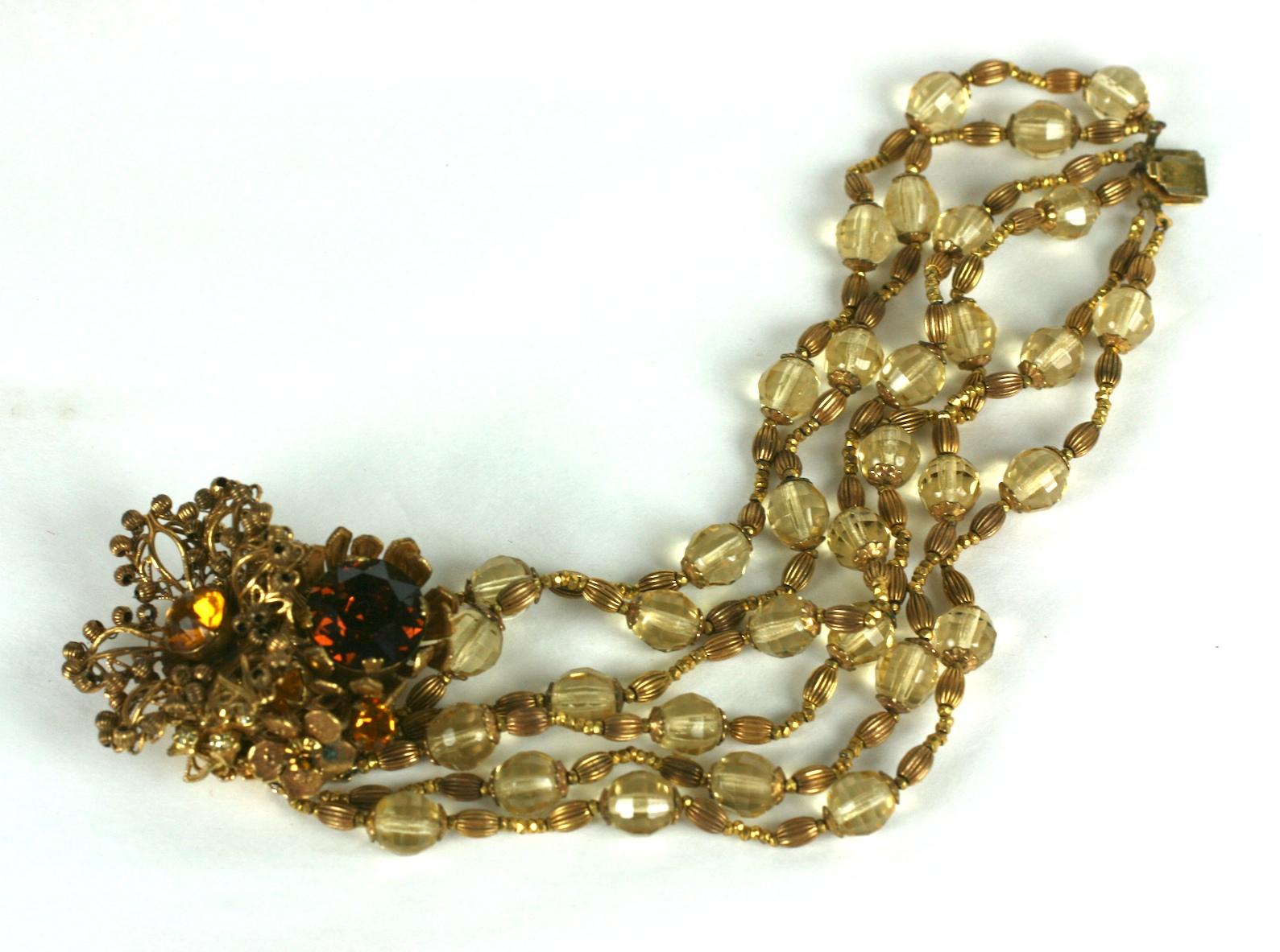Lovely Miriam Haskell Citrine Flower Multistrand Bracelet from the 1950's. Strands of faceted citrine glass beads with Russian gilt fluted and cut steel bed spacers. Hand wired clasp is composed of a large filigree flower edged with fluted gilt