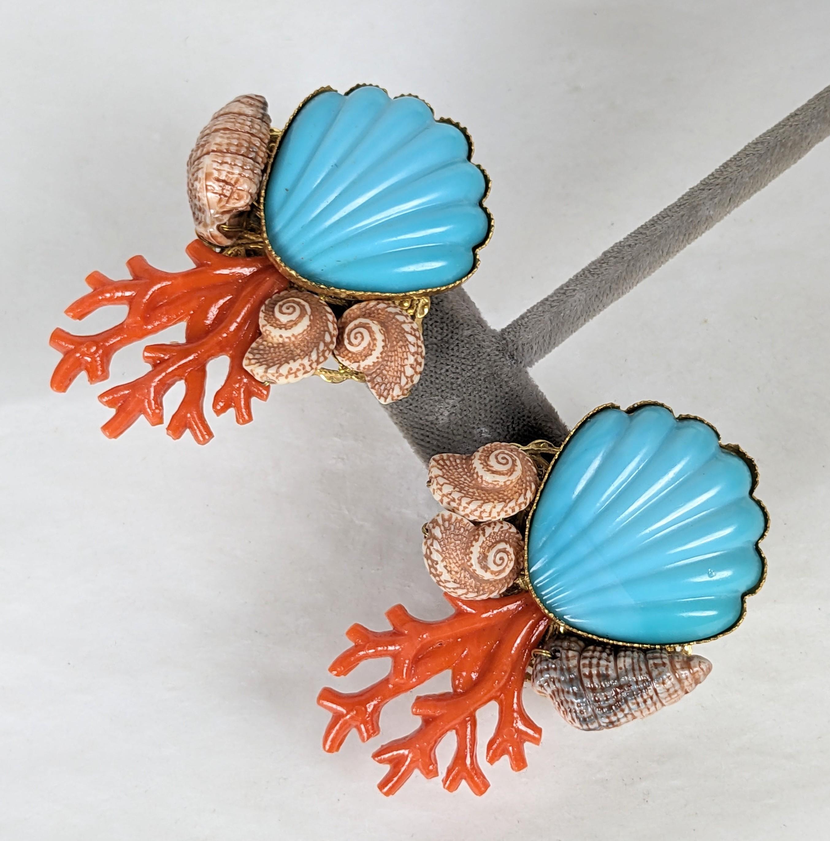 Jolies boucles d'oreilles à motifs de coquillages de Miriam Haskell avec attaches à clip. Un coquillage en résine turquoise est serti de faux coraux et de vrais coquillages. 
Grande échelle. États-Unis des années 1950.  2