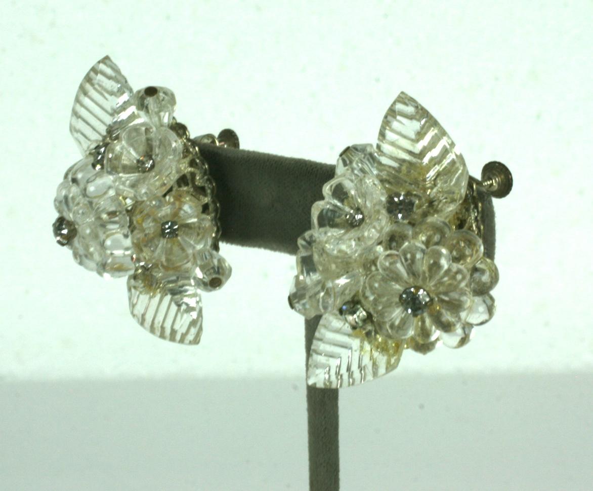 Miriam Haskell Crystal flower and leaf earrings of layered antique crystal elements mixed with pave crystal rhinestones. Clusters of flowers in the center are bordered by crystal scored leaves. 
Adjustable clip back fittings. Signed Miriam