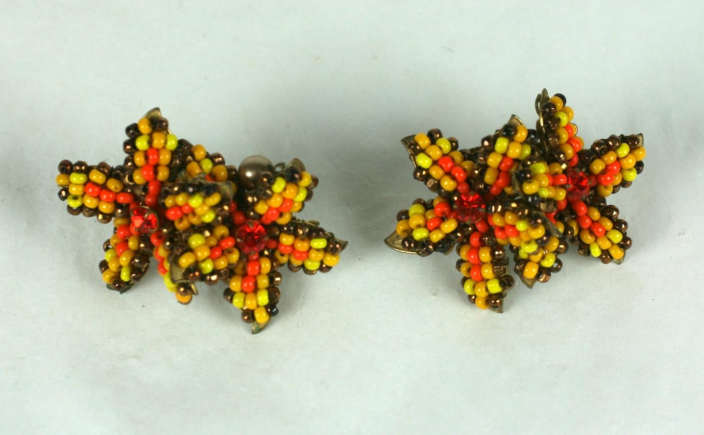 Ungewöhnliche Miriam Haskell Double Flower Earrings aus handgenähten gelben, orangefarbenen und kupferfarbenen Seeperlen. In der Mitte jeder Blüte befindet sich ein orangefarbener Kristall. Interessante dimensionale Konstruktion und tolle