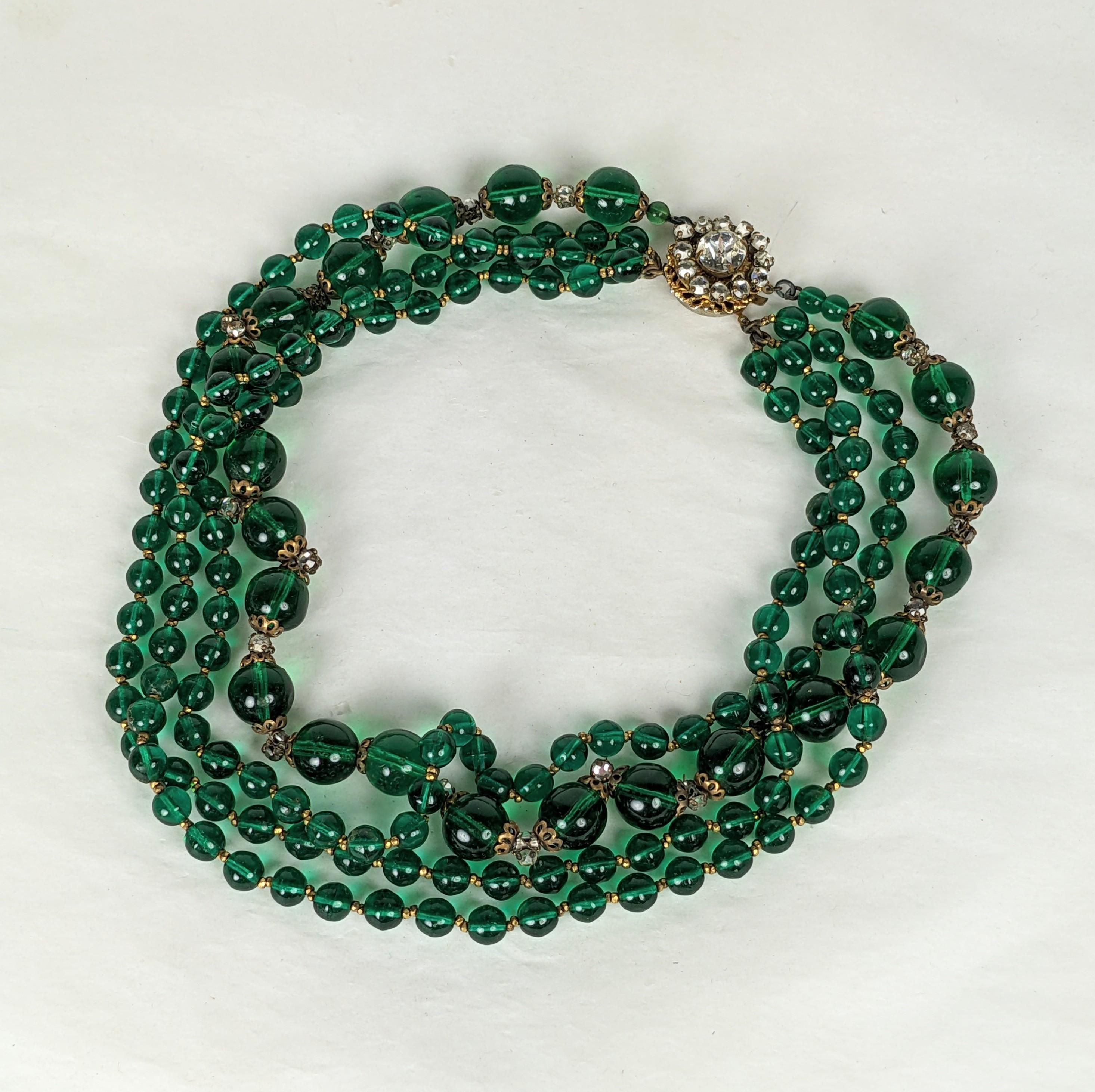 Miriam Haskell multi strand faux emerald Gripoix glass bead necklace of 4 bead strands with gilt plated cut steel bead spacers, hand sewn back to back crystal rose montes and pierced git flower bead caps. Signature prong set large crystal focal