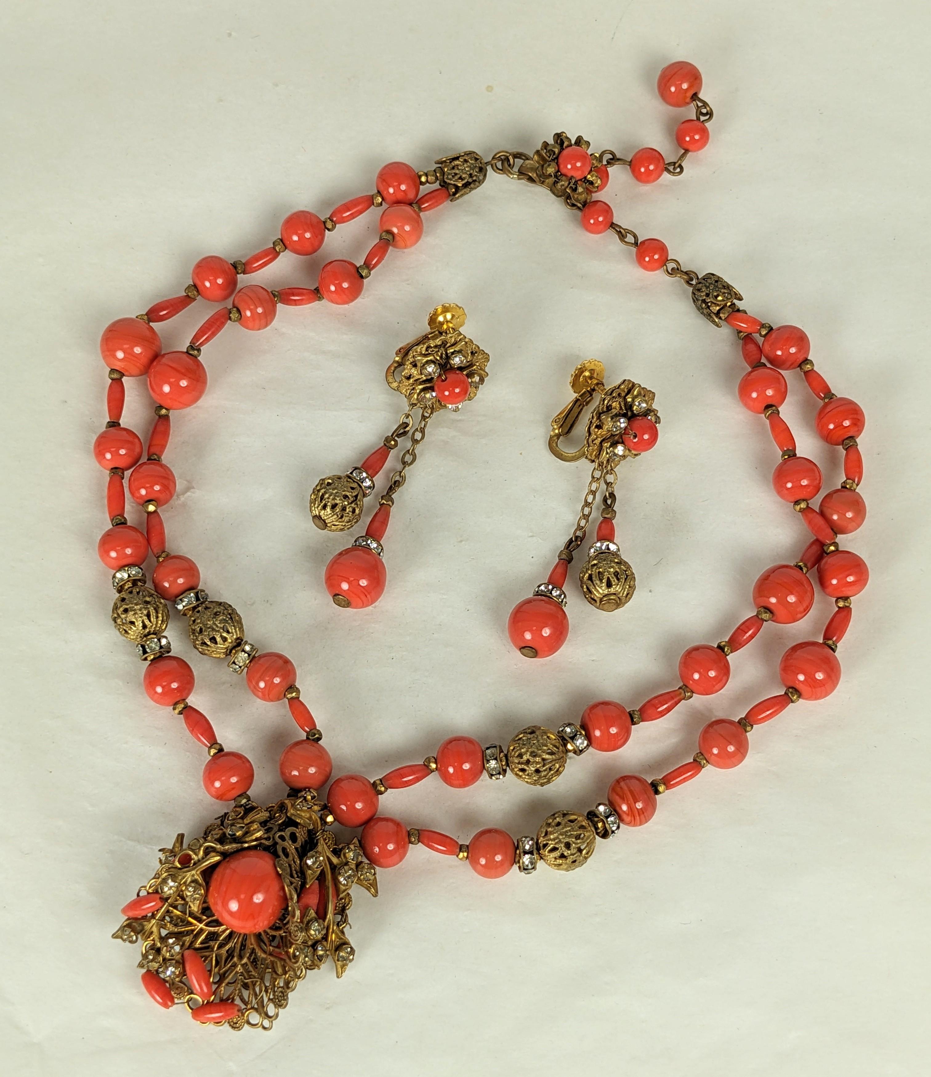 Miriam Haskell Faux Coral Filigree Suite with drop earrings from the 1950's. 2 strand beaded coral glass and filigree ball beads with pendant on hand sewn filigrees studded with crystals and faux coral beads. 
1950's USA. Clip Earrings 2