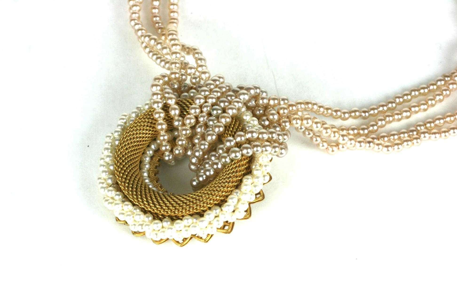 Miriam Haskell gilt and faux pearl necklace composed of a finely woven gilt brass circle mounted on a signature gilt filigree    bordered by a twisted rope of small faux pearls. Four pearl strands are looped through the circle form the body of the
