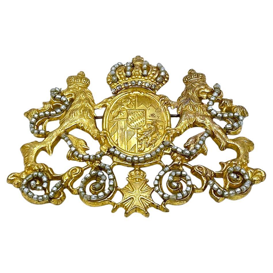 This is a Miriam Haskell gilt Bayern coat of arms brooch. This oversized Russian gold detailed coat of arms includes a pair of crowned lions rampant and a large crown on top of a shield in center and a Maltese cross at the bottom. Beyond that it has