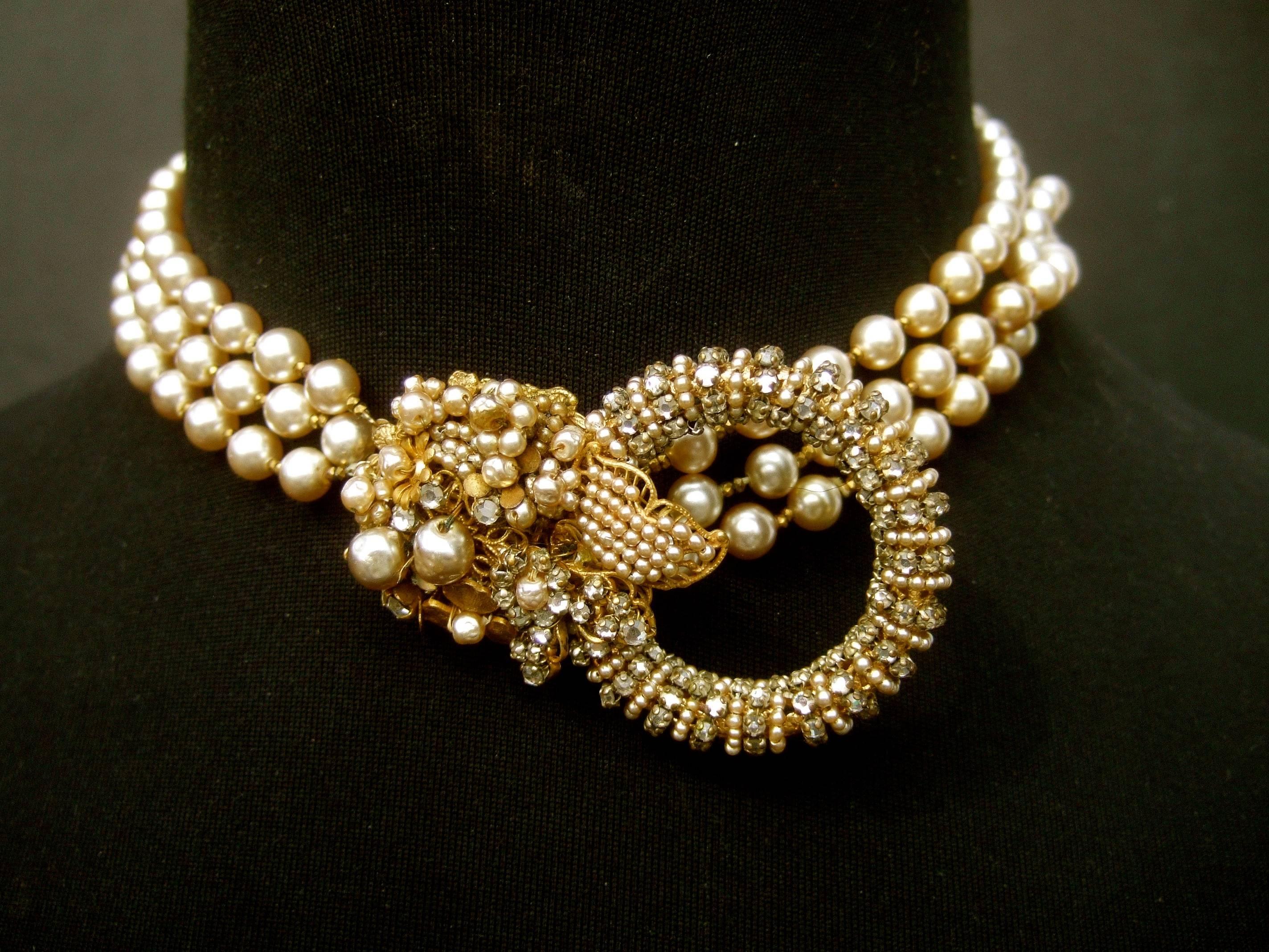 Miriam Haskell Exquisite glass pearl choker necklace c 1950s
The elegant choker style necklace is designed with three
strands of luminous glass enamel pearls 

Embellished with a wreath of tiny seed pearls and clear
diamante crystals; combined with