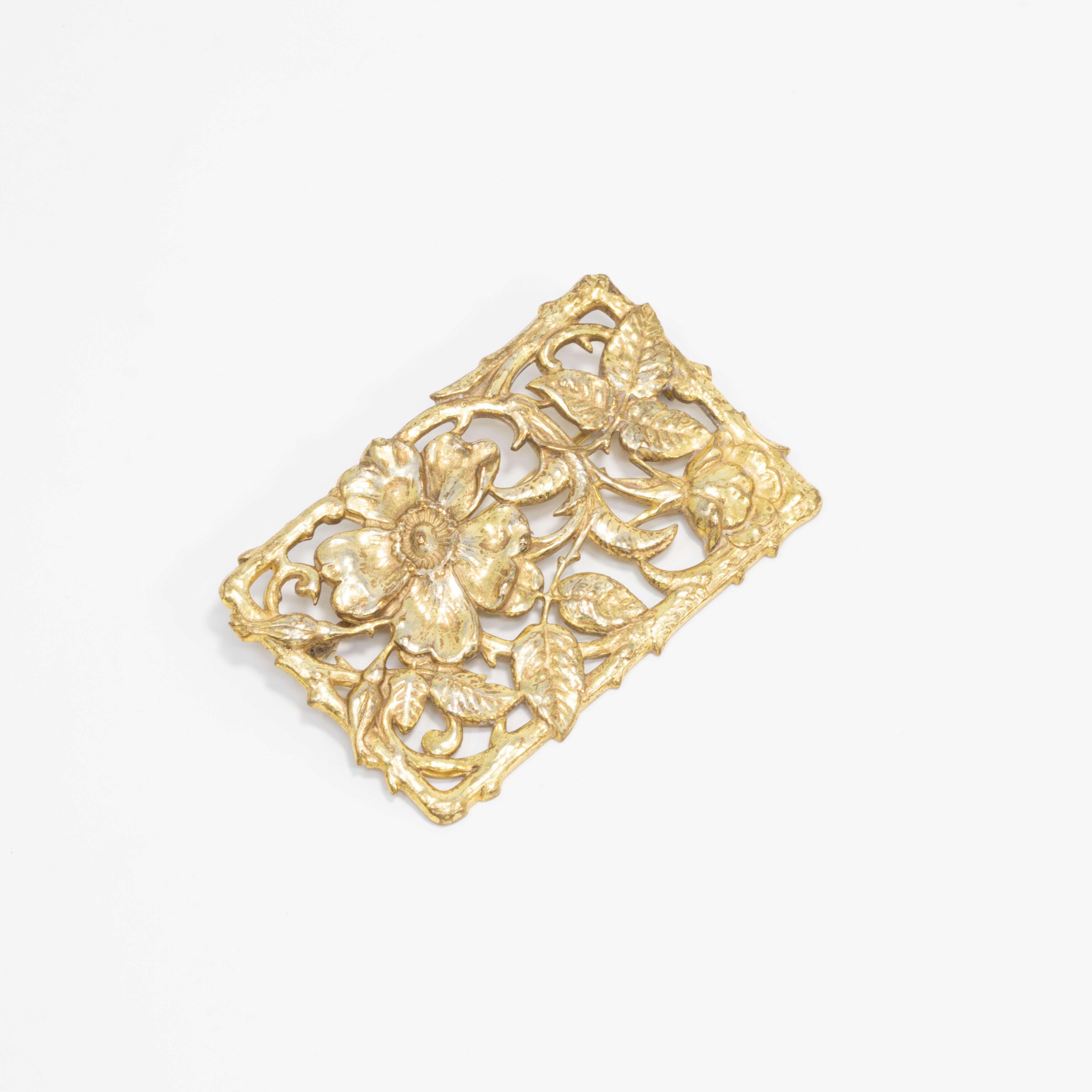 A floral-themed pin by Miriam Haskell. Rectangular, open filigree brooch with leaf and flower motifs.

Mid 1900s.

Hallmarks: Miriam Haskell