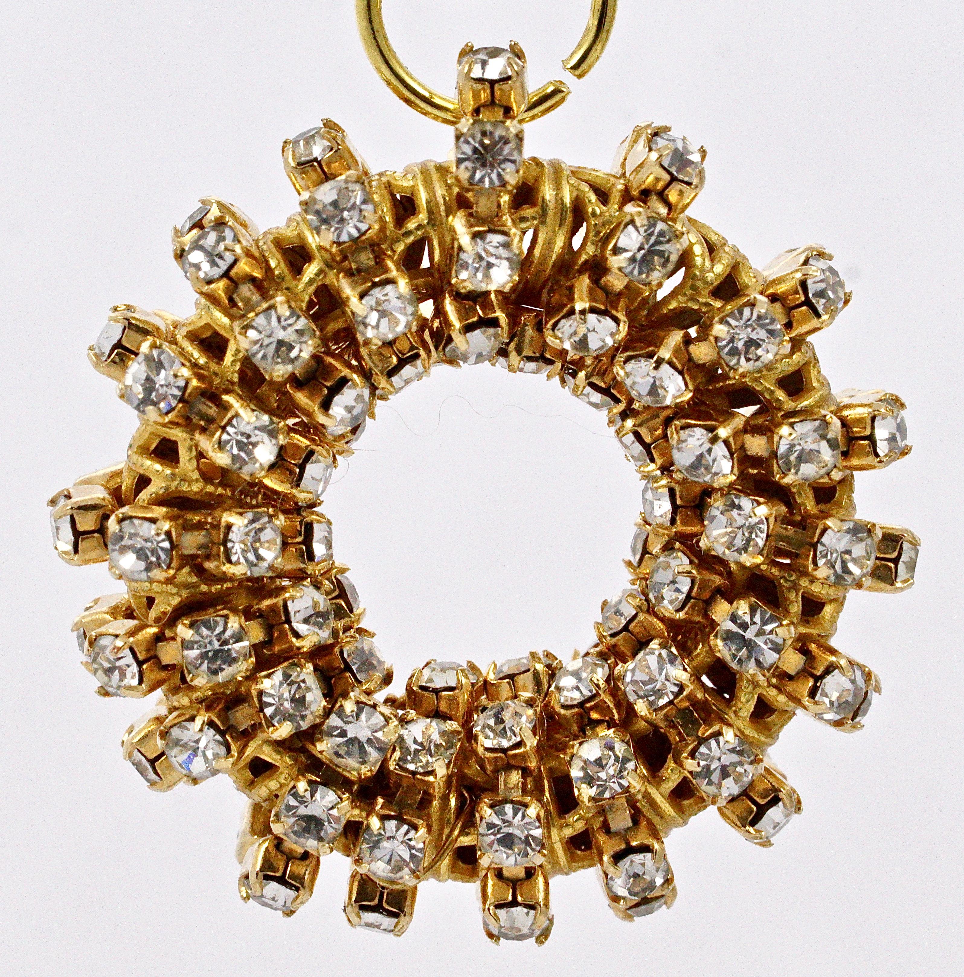 
Boucles d'oreilles à clip Miriam Haskell en ton or avec un anneau doré avec des rangées de strass clairs en relief, suspendues à un grand strass facetté serti, elles sont reliées par un anneau de saut (qui n'est pas d'origine). Longueur 5cm / 1.97
