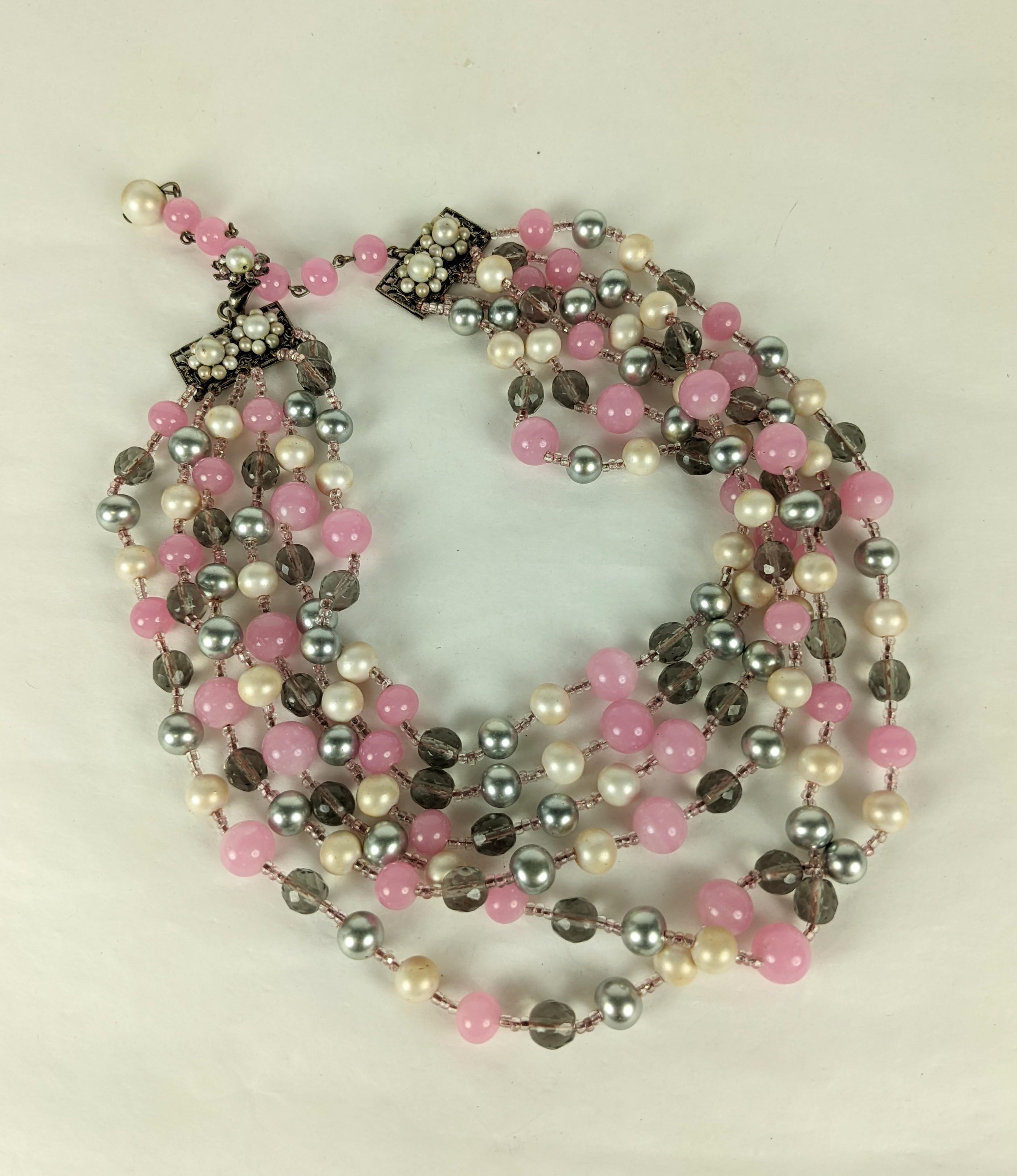 Dramatique Miriam Haskell gris, rose et perles d'eau douce en configuration graduée à 6 brins. Composé de fausses perles d'eau douce grises et blanches avec des perles en pate de verre rose et des cristaux facettés fumés, le tout séparé par de