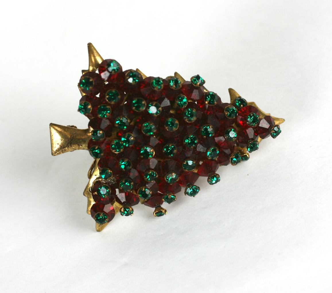 La rare broche en forme de sapin de Noël de Miriam Haskell. L'arbre de Noël de forme naturaliste est cousu à la main avec des cristaux facettés Swarovski rouge foncé et des cristaux rose monte vert émeraude. Serti dans une forme inhabituelle d'arbre