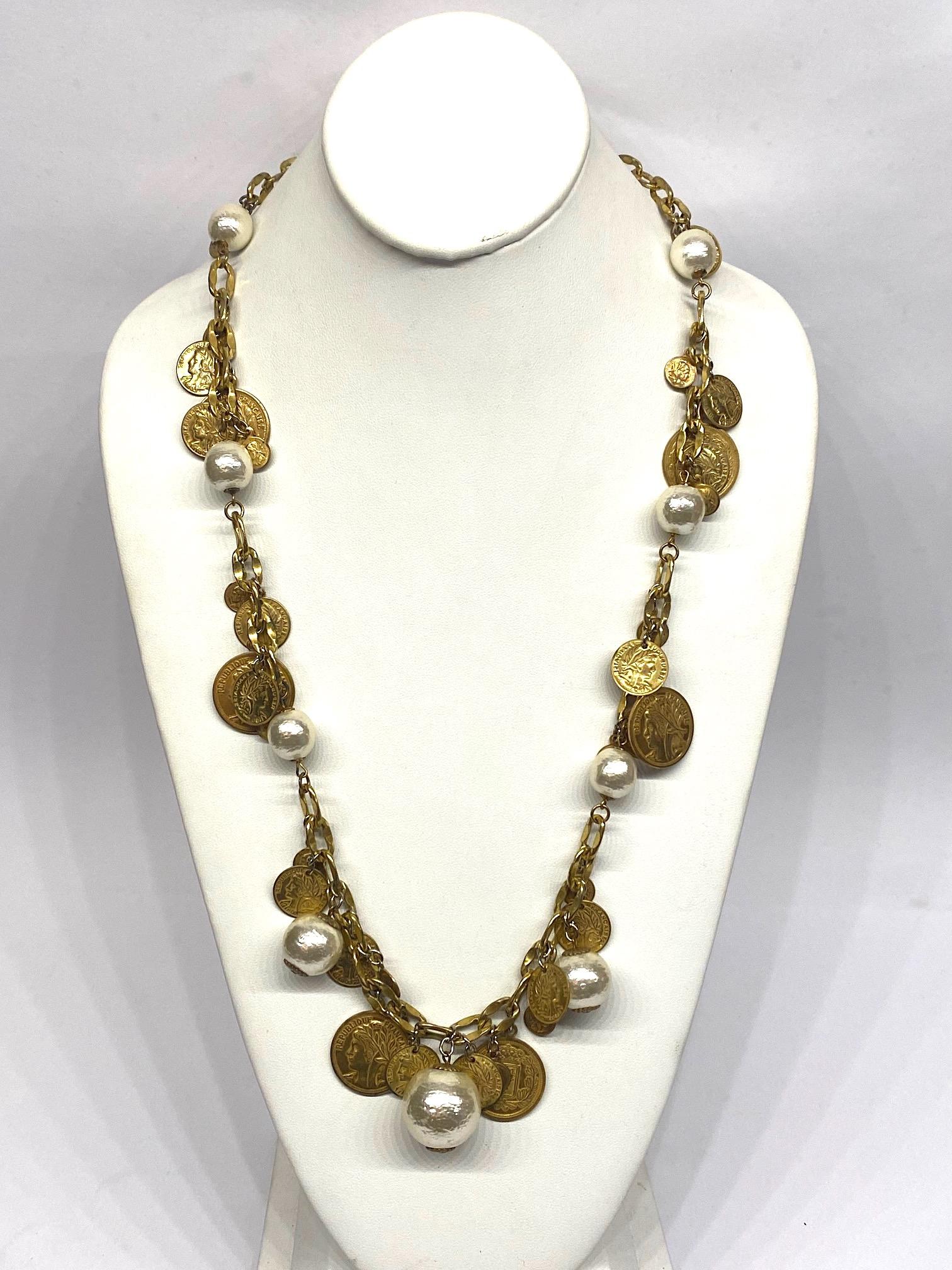 A wonderful 1960s Miriam Haskell long chain necklace with coin and pearl charms. The necklace is in Haskell's signature Russian gold finish of antique mat gold. Each link is .38 of an inch wide by .5 of an inch long. The 33 inch long necklace has