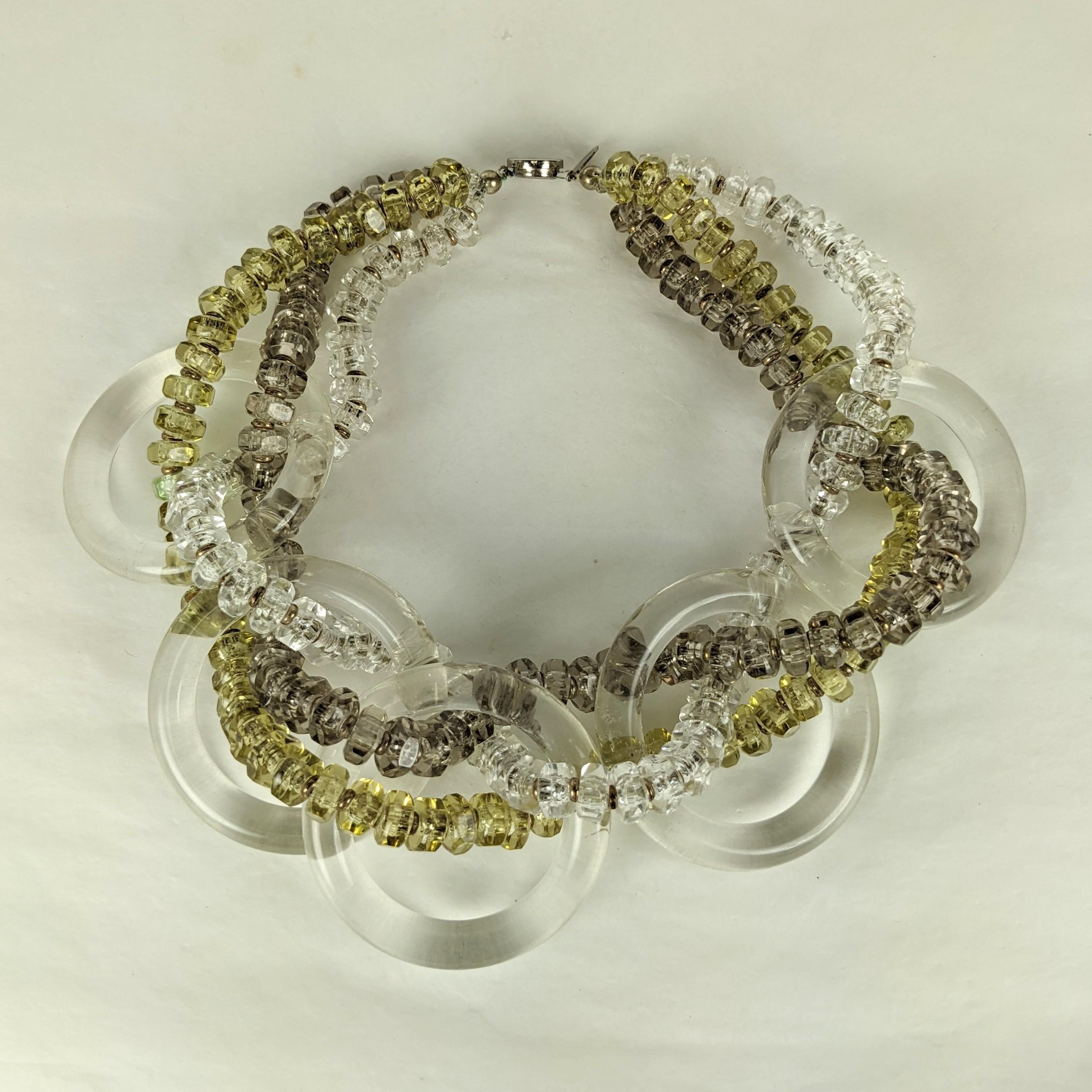Amusant collier à cerceaux en lucite Miriam Haskell des années 1960, tressé avec des perles de cristal, d'olivine pâle et de lucite de couleur fumée pâle, avec des entretoises en métal doré. Une échelle et un design imposants. Signé Miriam Haskell.