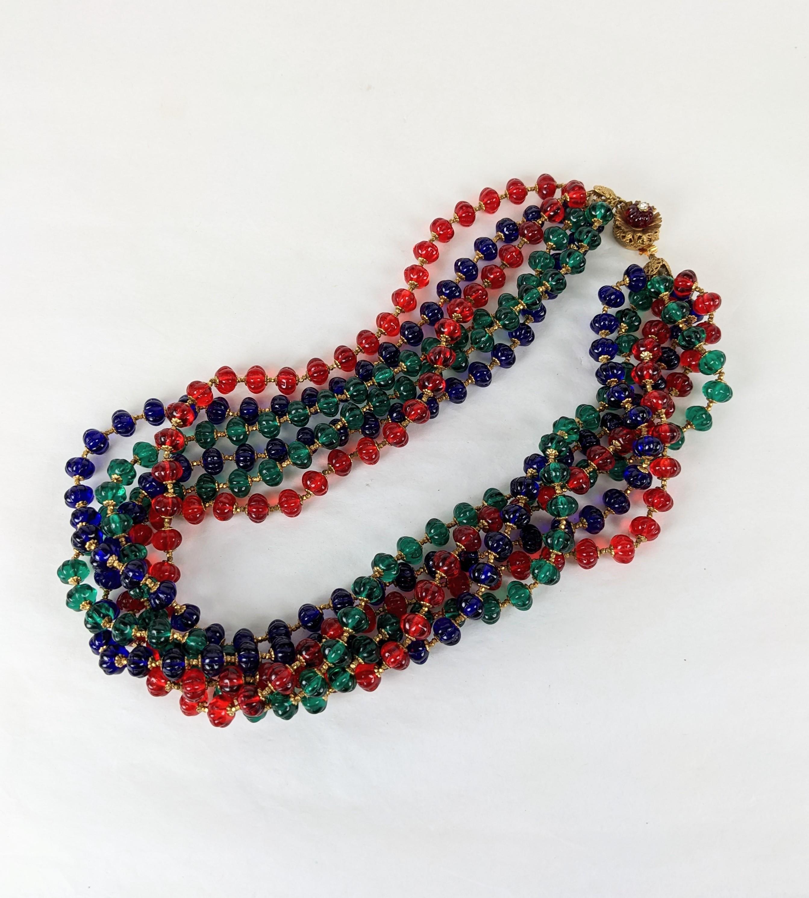 Exceptional Haskell Melon Cut Gripoix Glass Multi Bead Torsade from the 1950's. Ruby, emerald, sapphire cotele melon cut Gripoix beads are used for a 6 strand torsade with a ruby bead clasp. Hundreds of Russian gilt cut steel spacers and caps are