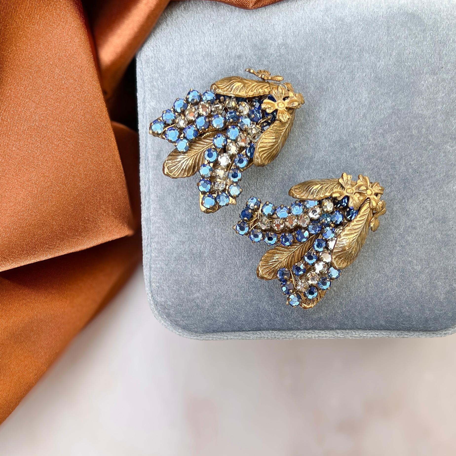 These rare and pretty clip on earrings were created in 1950s by the Miriam Haskell company. 

Condition Report:
Excellent

The Details...
These earrings are constructed from gilded metal. They each feature gilded metal flower and leaf motifs mounted