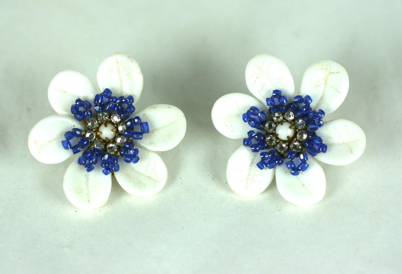 Charming Miriam Haskell Milk Glass Flower earrings with hand sewn seed bead detailing. Milk glass petals form the flower with a center of purpley blue seed beads with a crystal diamante center. Clip back fittings.
1950's USA. Excellent condition.