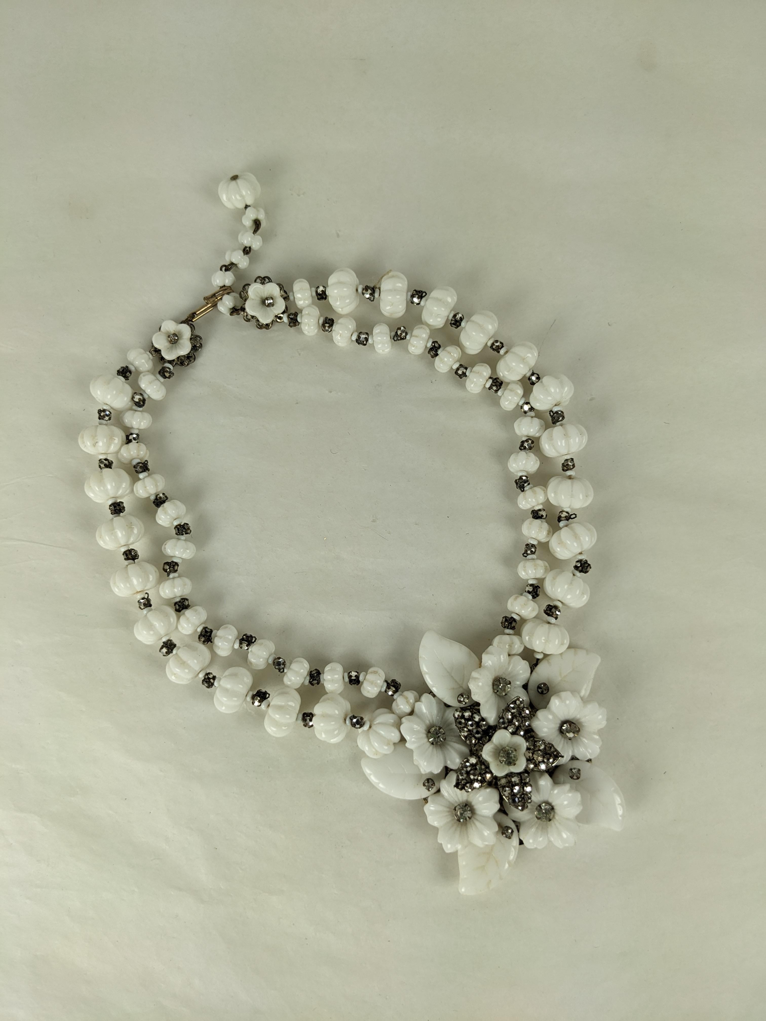 Splendida collana con ciondolo a forma di fiore in vetro di latte di Miriam Haskell, risalente agli anni Quaranta. Perle di vetro al latte scanalate con distanziatori cuciti a mano sorreggono un grande ciondolo di foglie in vetro colato e cristalli