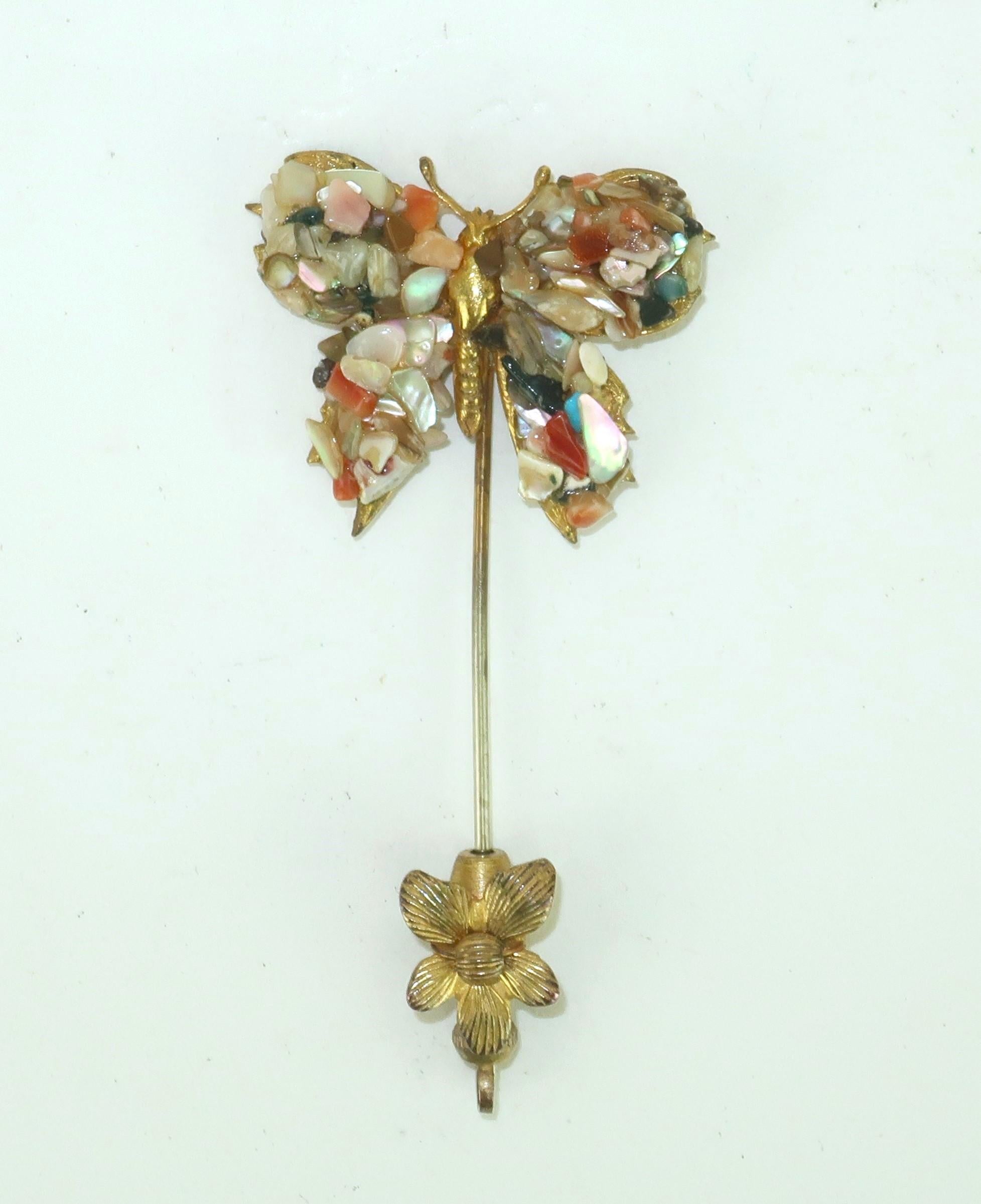 C.1950 Miriam Haskell gilded metal stick pin in the form of a delicate butterfly embellished with a mosaic of semi precious stone chips including carnelian, jade and mother-of-pearl.  The pin is capped off with a metal flower for the ultimate