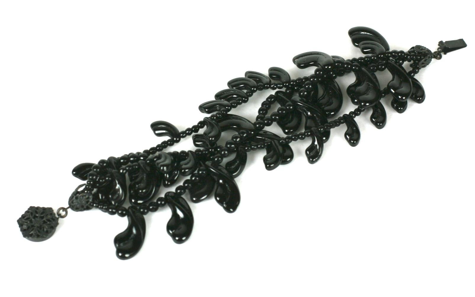 Miriam Haskell four strand jet pate de verre petal bracelet. The hand made glass petals strung with rounded jet seed bead spacers. Signature clasp and filigree caps of black japanned metal, Signed: Miriam Haskell.
Excellent Condition. 
Length