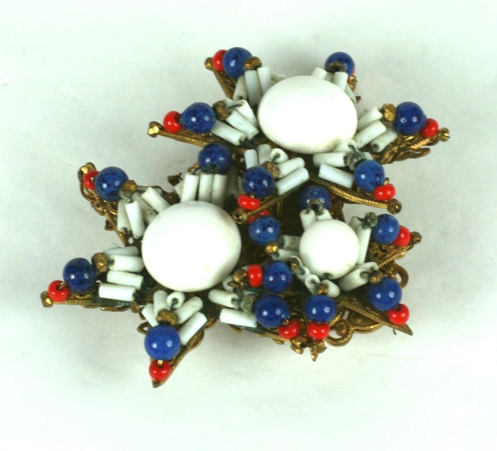 Miriam Haskell Patriotic Star Brooch of handwoven beads with pate de verre elements in a striking dimensional brooch. Signature Russian gilt filigree backing. 
2.5