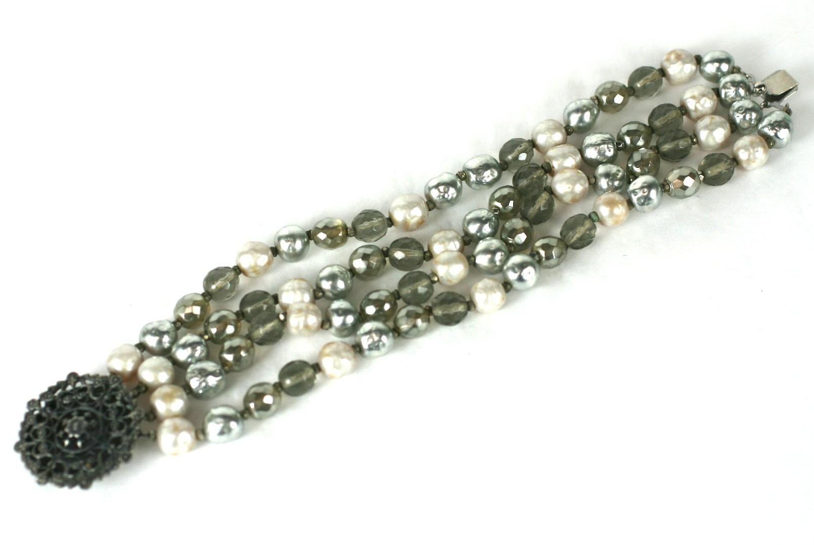 Miriam Haskell Pearl and Crystal Bead Bracelet. 4 strand bracelet with faux cream, grey pearls and smokey crystal beads. Antique silver filigree clasp. 
7.5