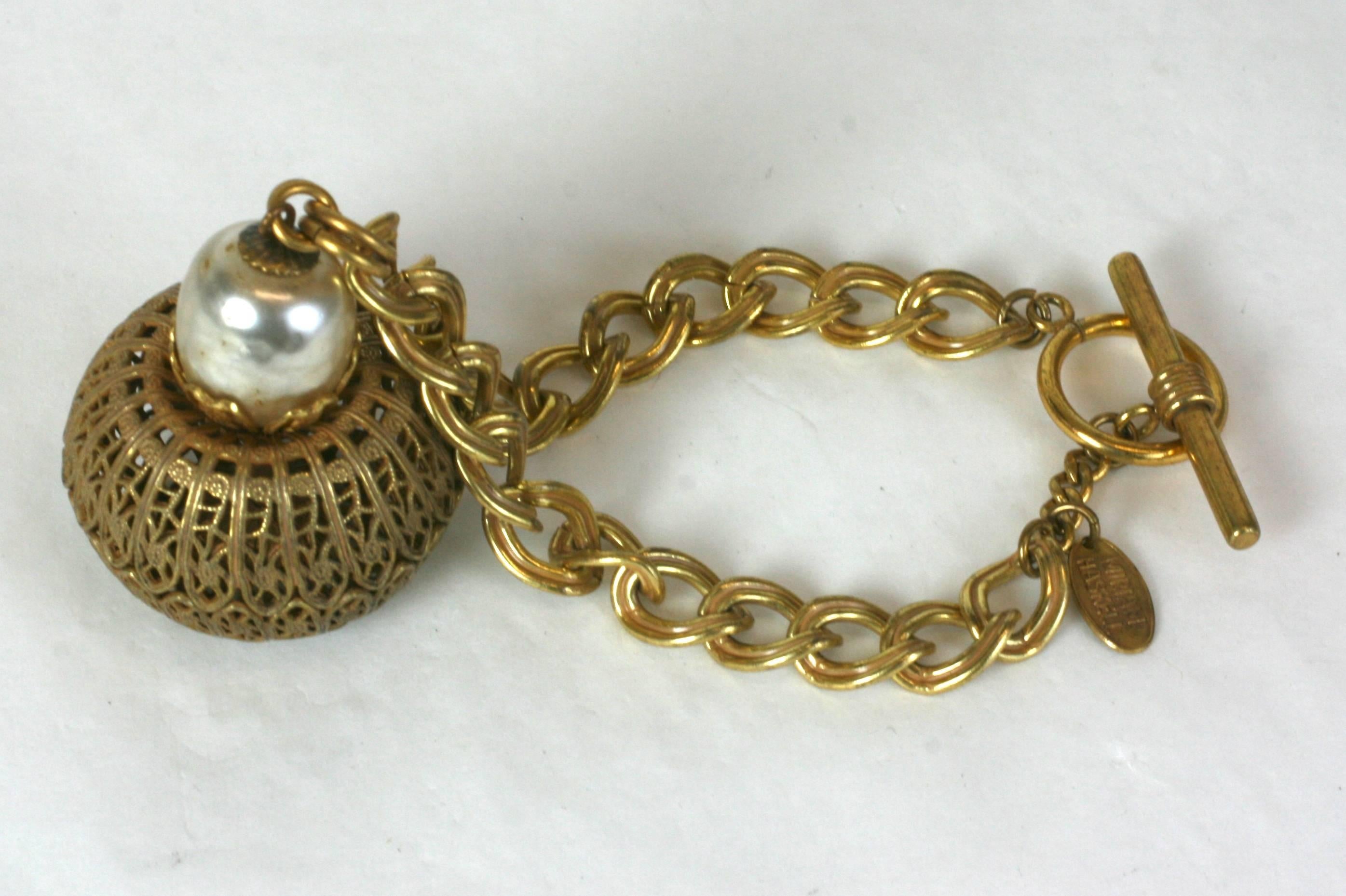 Oversized Miriam Haskell  signature Russian gold filigree domed cham fob bracelet of gilt ribbed chain with faux baroque nailhead pearl and toggle clasp.  
A companion cocktail ring is also on 1st Dibs item LU46614412 .
1950's USA. Signed. Bracelet