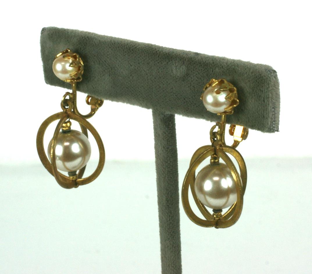 Les boucles d'oreille Miriam Haskell en fausse perle et en dorure russe sont ornées d'anneaux en forme de Saturne et d'intercalaires en microbilles d'acier plaqué or. Excellent état. 
Longueur 1,25