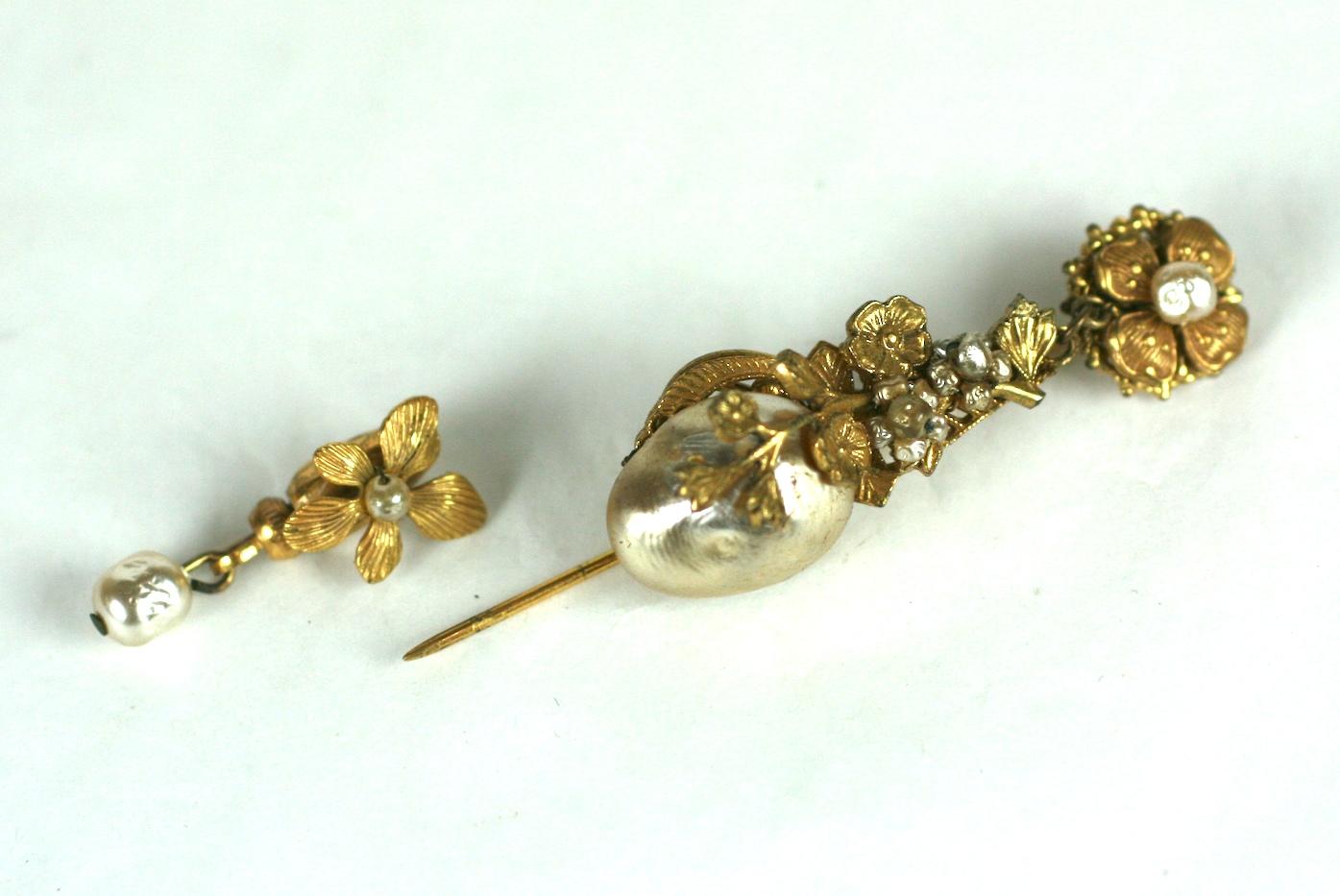 Miriam Haskell articulated Victorian Revival stick pin brooch of signature Russian gilt metal  filigrees and classic vari sized faux baroque pearls.
Pearl embellished floral safety lock with baroque pearl drop.
Excellent Condition
L 3.13