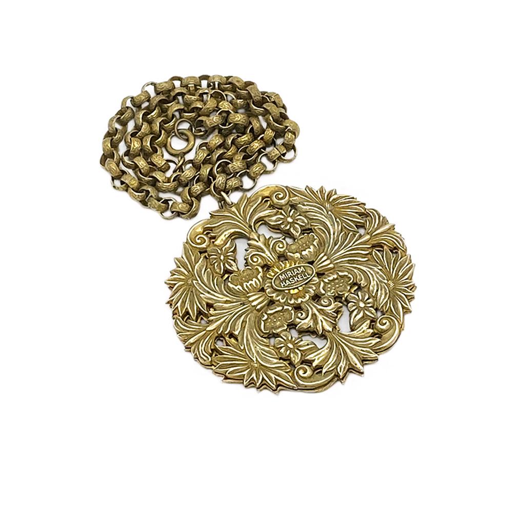 Here is a 1960s Miriam Haskell Russian gold finished brass necklace with medallion pendant. This textured link chain necklace comes with a large cut out flower patten medallion pendant. Miriam Haskell was an American designer of costume jewelry who