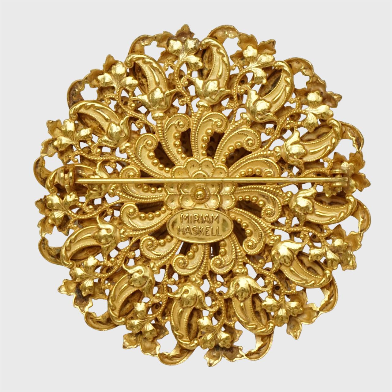 Miriam Haskell, belle broche dôme russe plaquée or, avec un joli motif orné de fleurs et de feuilles. 

Diamètre de mesure 5,8 cm / 2,28 pouces. La broche est en très bon état.

Il s'agit d'une magnifique broche complexe avec la patine d'or russe de