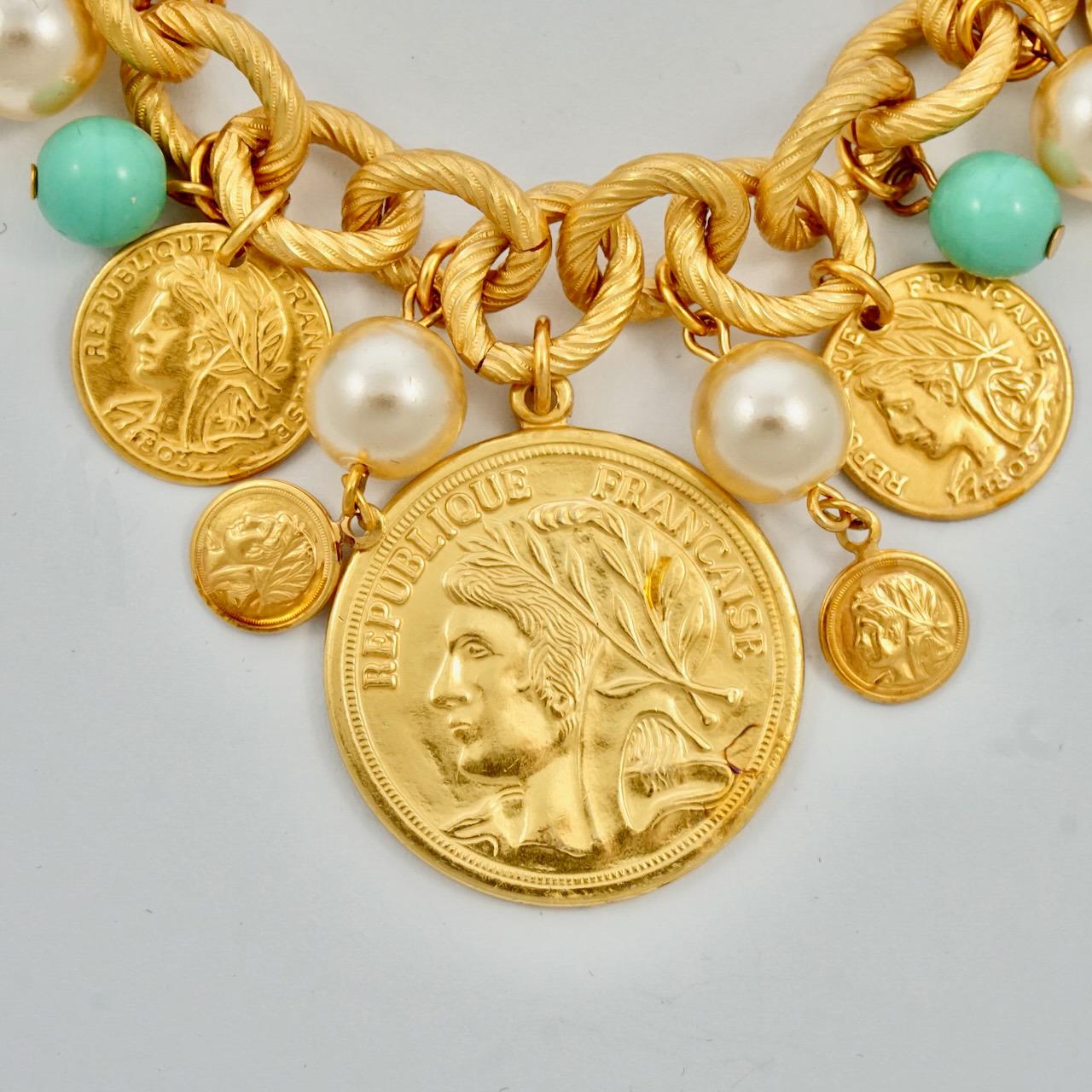Fabulous Miriam Haskell Russian gold plated charm bracelet, with faux pearls and turquoise glass, and featuring Greek and French decorative coins. Measuring length 20.3 cm / 8 inches, and the largest coin is diameter 2.9 cm / 1.14 inch. The bracelet