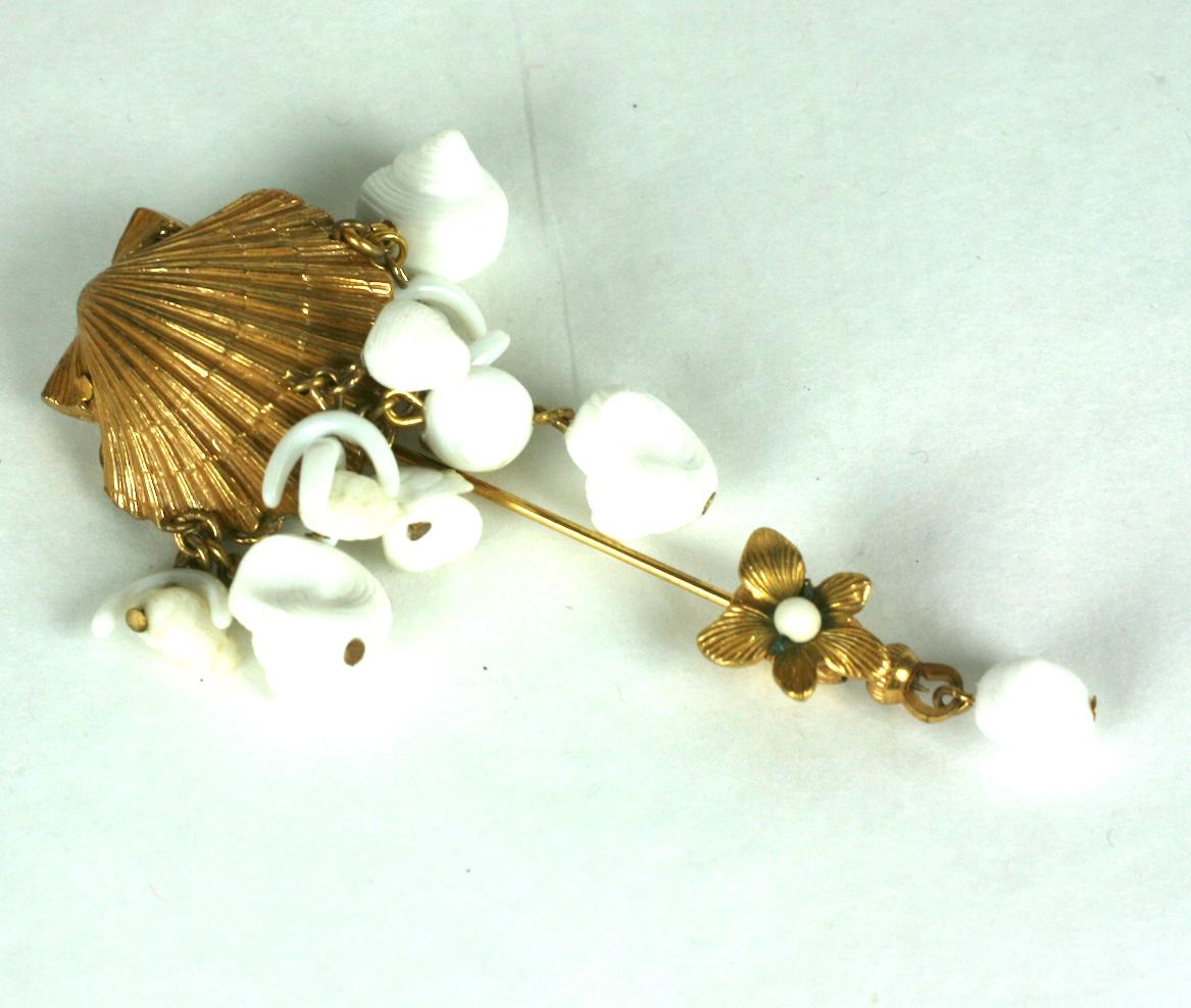 Miriam Haskell Sea Shell Jabot Pin.  The signature Russian gilt scallop shell trimmed with white pate de verre faux branch coral and small white bakelite shells. Flower safety lock.
Excellent Condition.
Length 3.25