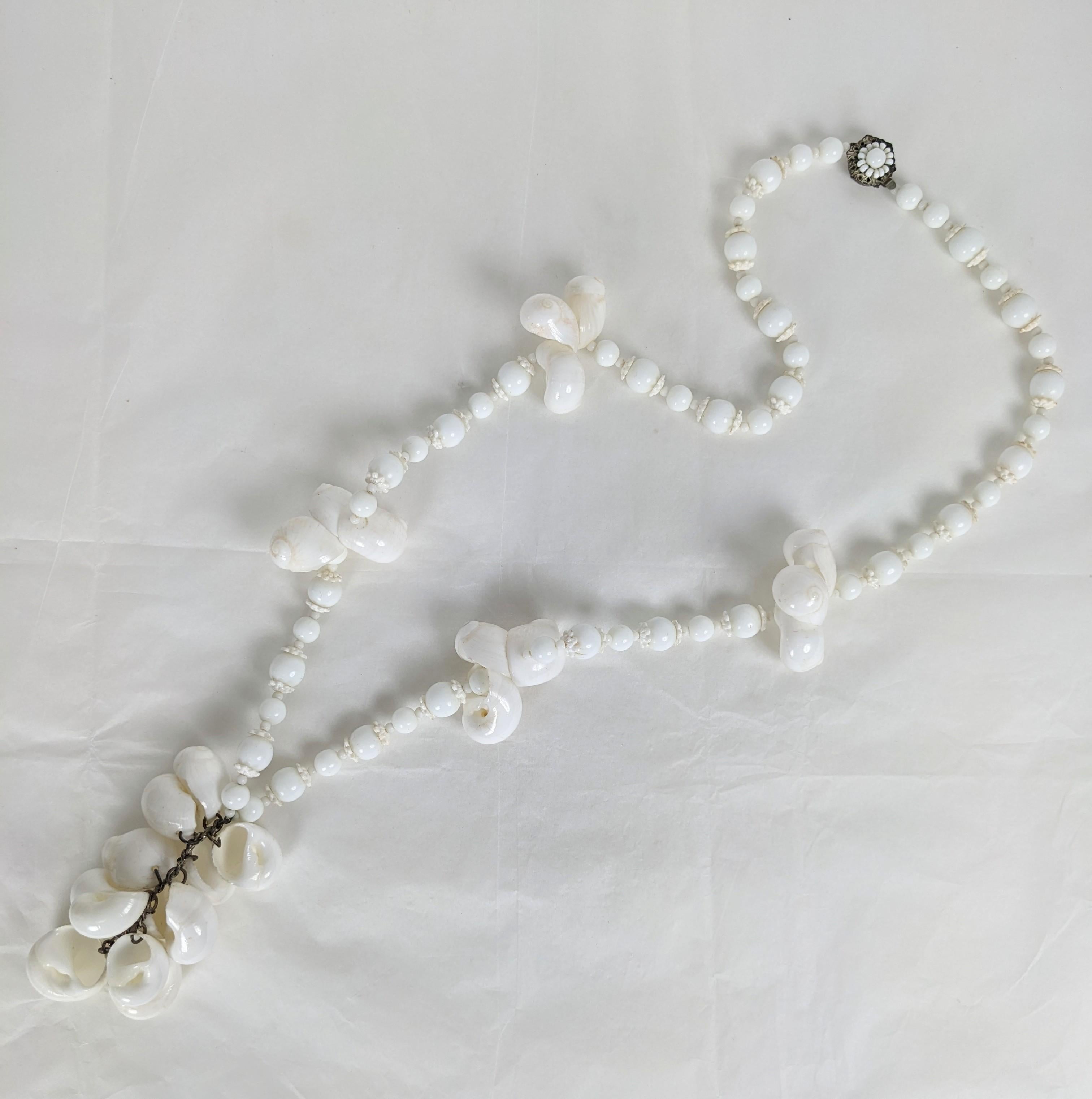 Encantador collar colgante de concha Miriam Haskell de los años cincuenta. Conjunto con pequeñas conchas blancas, cuentas de cristal de leche y separadores florales blancos. Cierre de racimo firmado. Años 50, EE.UU. Collar 30