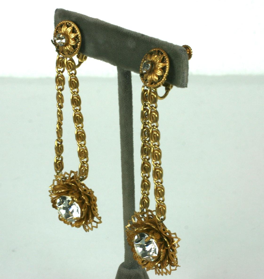 Miriam Haskell Victorian Revival filigree pendant ear clips in Signature Russian Gilt. Flower head gilt filigrees with large faceted crystal pastes are suspended by two book chains. 
Clip back fittings. 
Excellent Condition. 1950's USA.  . 
Length