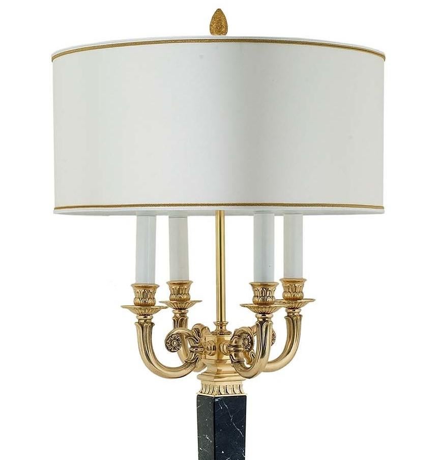 A perfect accent for midcentury and traditional interiors alike, this table lamp showcases a candelabra-inspired design with a cylindrical shade in white fabric with golden rims. The square base tapers towards the superb stem crafted of black marble