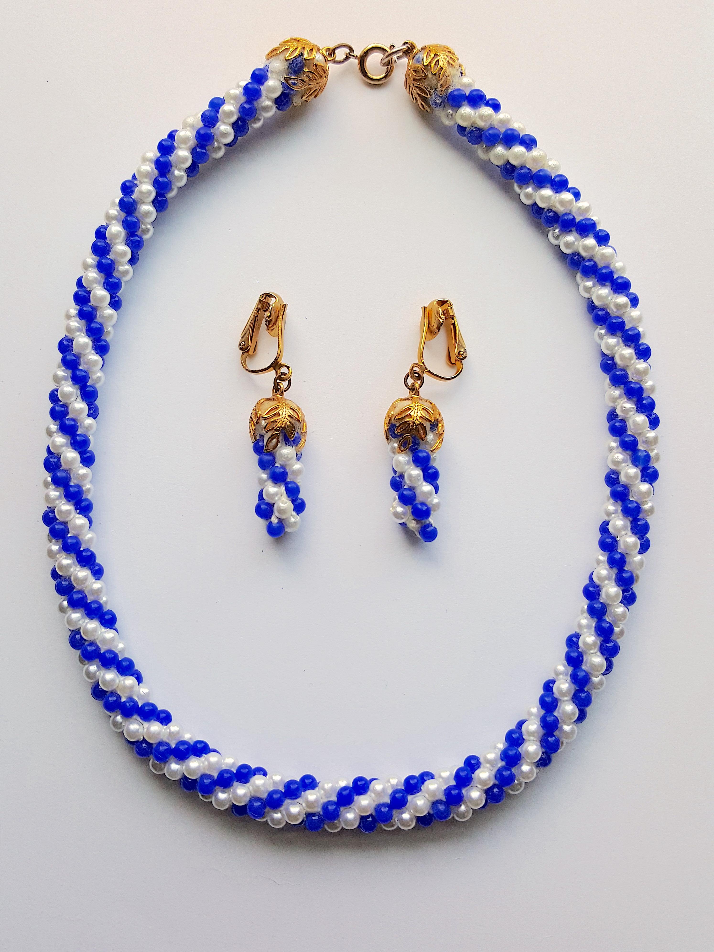 During the Art Deco period, Miriam Haskell's first designer Frank Hess designed this blue-and-white glass-beaded hand-sewn torsade set of dangle earrings and a choker necklace, whose knotted string is capped with their characteristic Russian-gilt