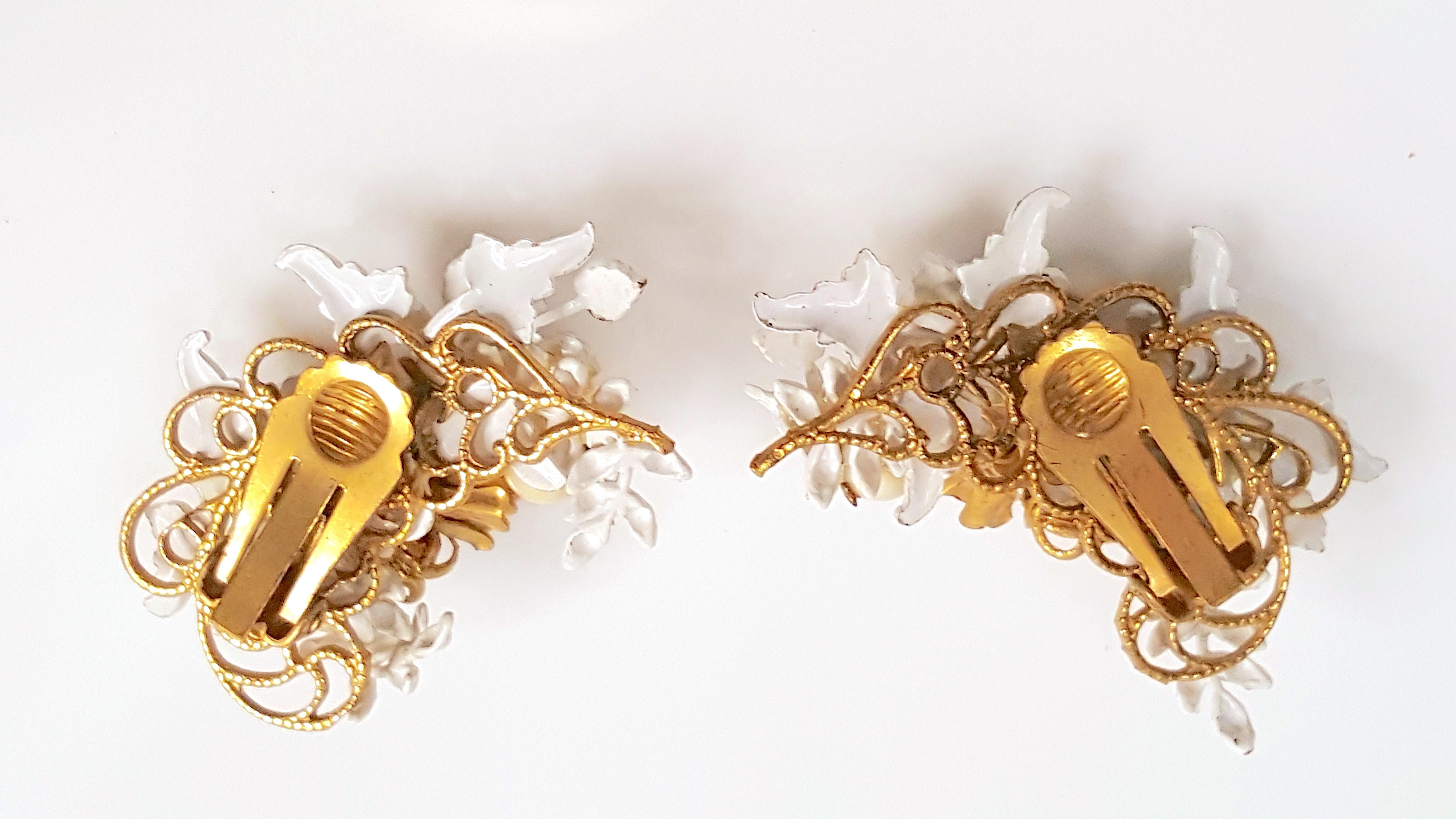 Before the brand signature was added in 1947, Miriam Haskell's first designer Frank Hess since 1926 designed these asymmetrical Baroque-style climber earrings with hand-painted white-and-ecru enamel leaves, crystal and glass beads, and Russian-gold