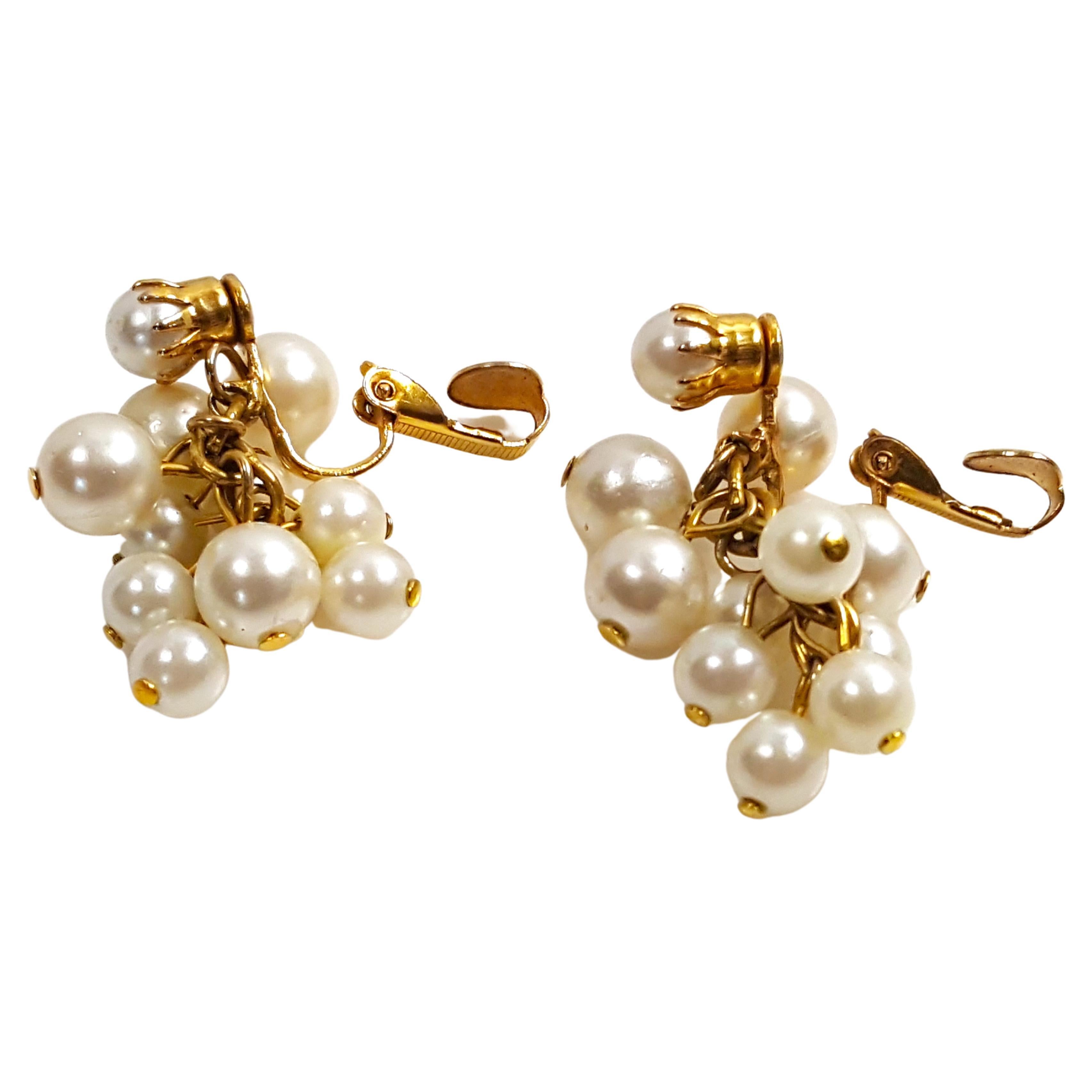 Miriam Haskell's first designer since 1926 Frank Hess created in a Baroque style these handcrafted cluster-cascade-dangle earrings that feature coated-glass ecru round faux-pearls whose yellow Russian-gilt brass findings are mixed with 24 karat