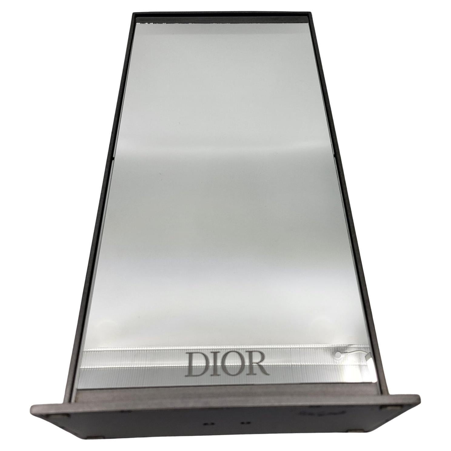 Il miroir double face Christian Dior è un accessorio elegante e funzionale che conferisce un tocco di raffinatezza a tutto l'ambiente. Con la sua struttura in métal gris argent, riflette la luce in modo sottile, creando un'atmosfera luminosa nella