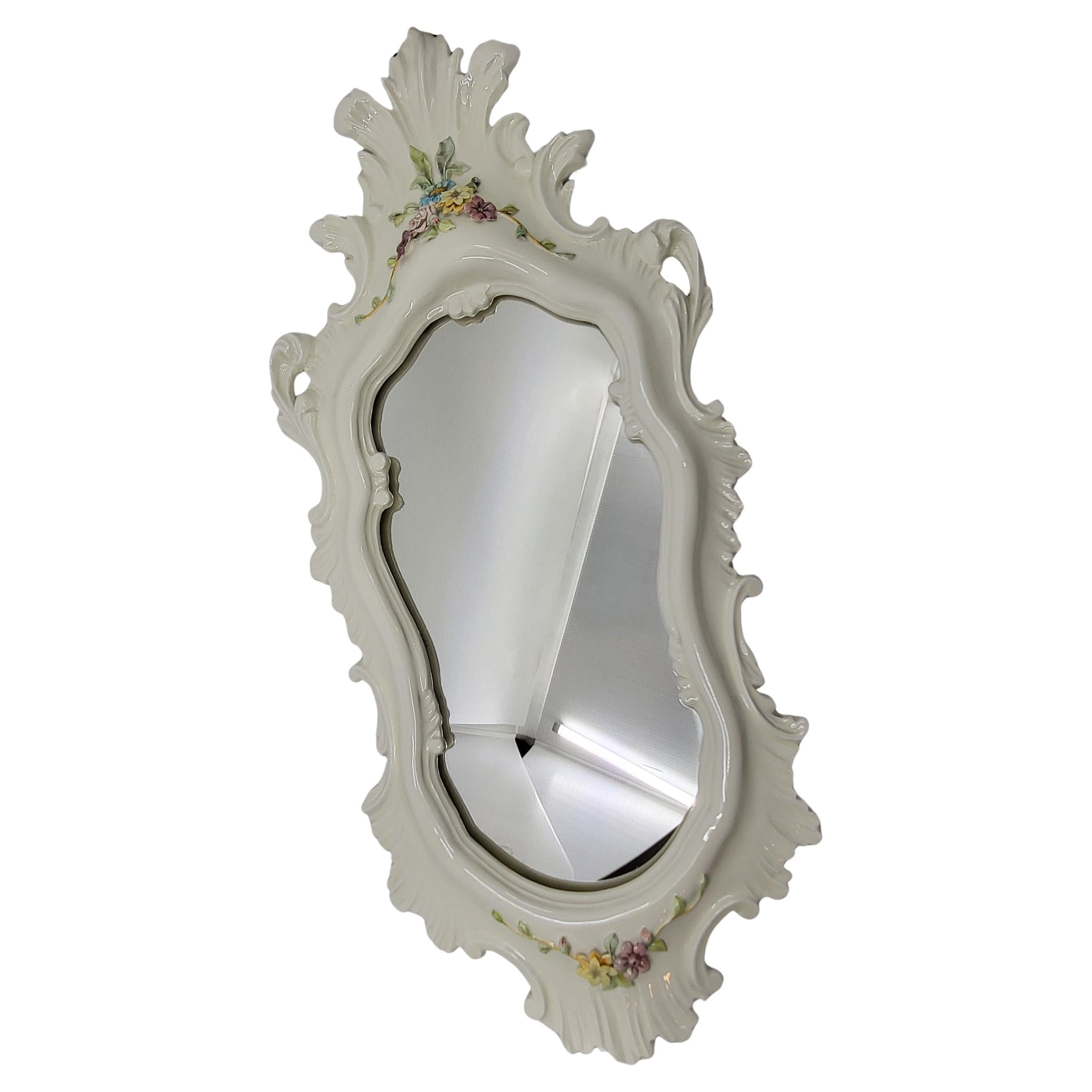 Gran miroir, La Farnesiana de Parme, diseñado por Carlo Corvi, realizado en cerámica mayólica blanca, está decorado con flores delicadas y mide 70 centímetros sobre 32. Perteneciente al año 1950, su estado es magnífico. Conviene precisar que le