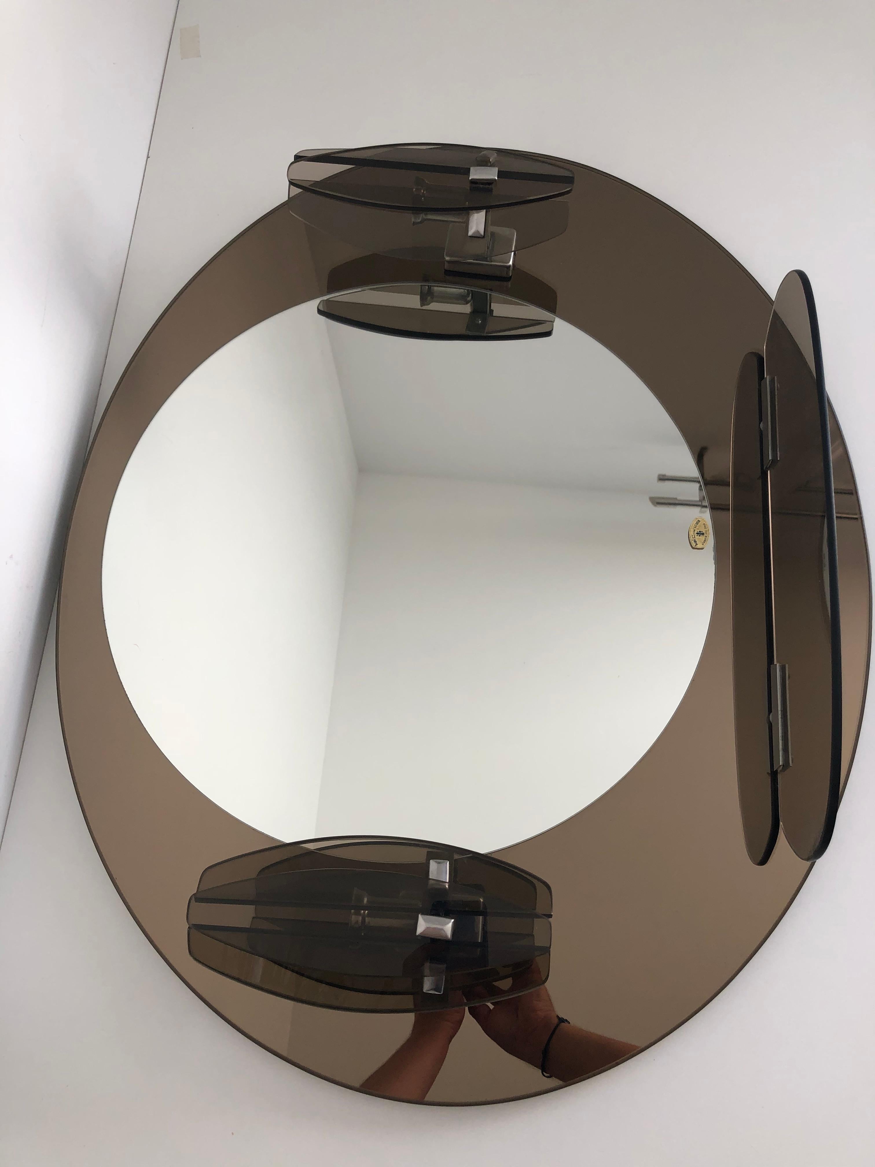 Miroir Lupi Cristal Luxor, avec 2 appliques intégrées et tablette, Made in Italy, fond couleur miroir marron, état proche du neuf, crochet de fixation murale au dos du miroir. 
Dimensions longueur 77 cm, hauteur 64 cm, profondeur 11