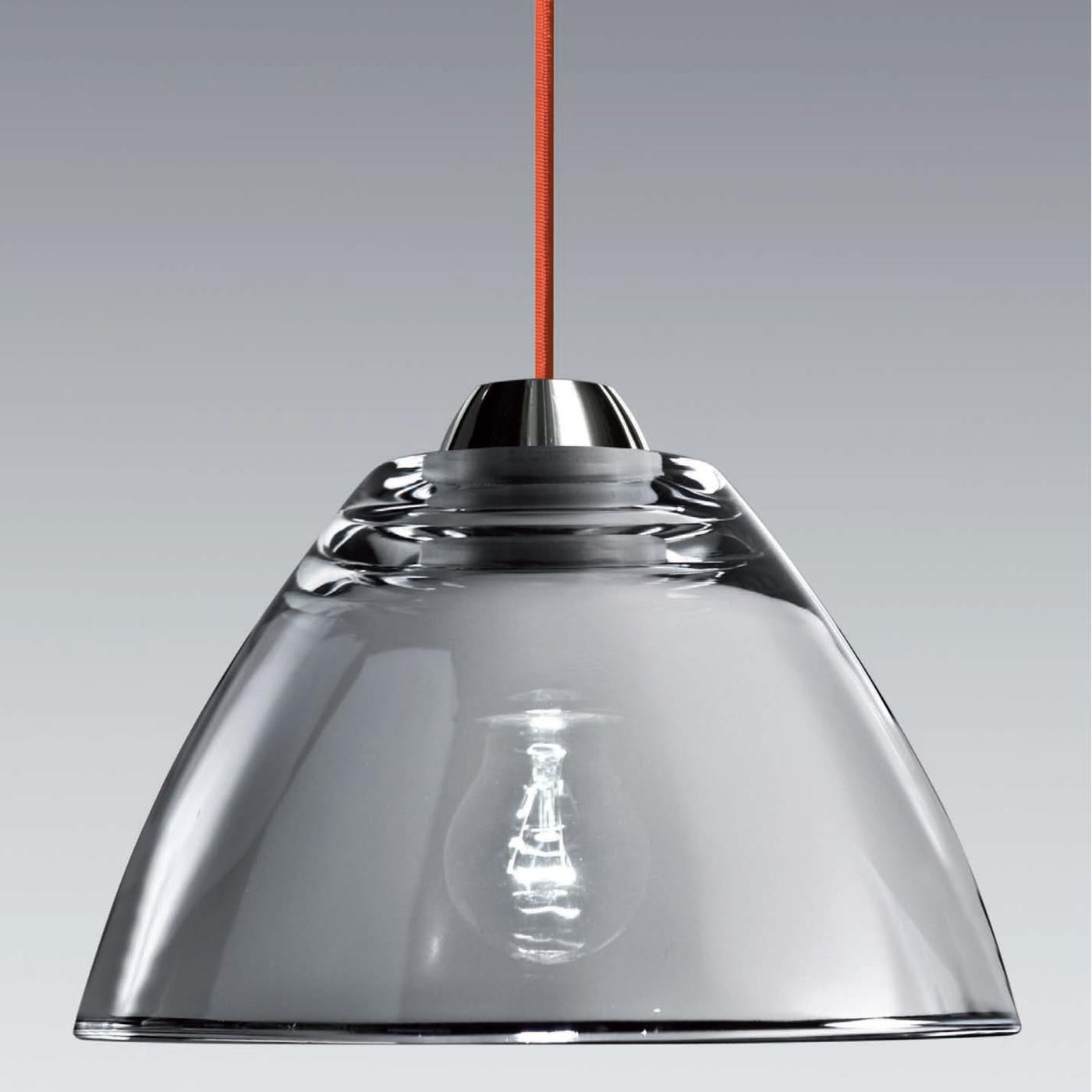 Modern and versatile, this pendant lamp embodies the timeless elegance of glass. The polished chrome frame perfectly complements the conical diffuser of blown glass enriched by a sophisticated mirror finish that is suspended from the ceiling with a