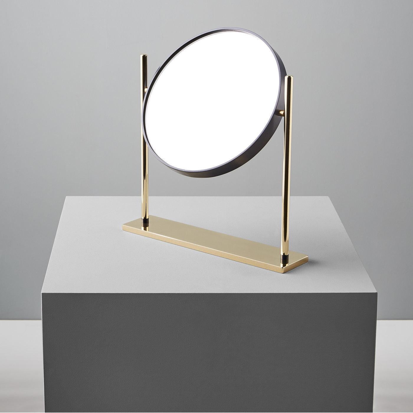 This piece was designed by Federica Biasi and is ideal as mirror in a small study or bathroom mirror. Its precious silhouette displays perfectly proportioned lines that mix the straight elements of the base with the round frame of the mirror with