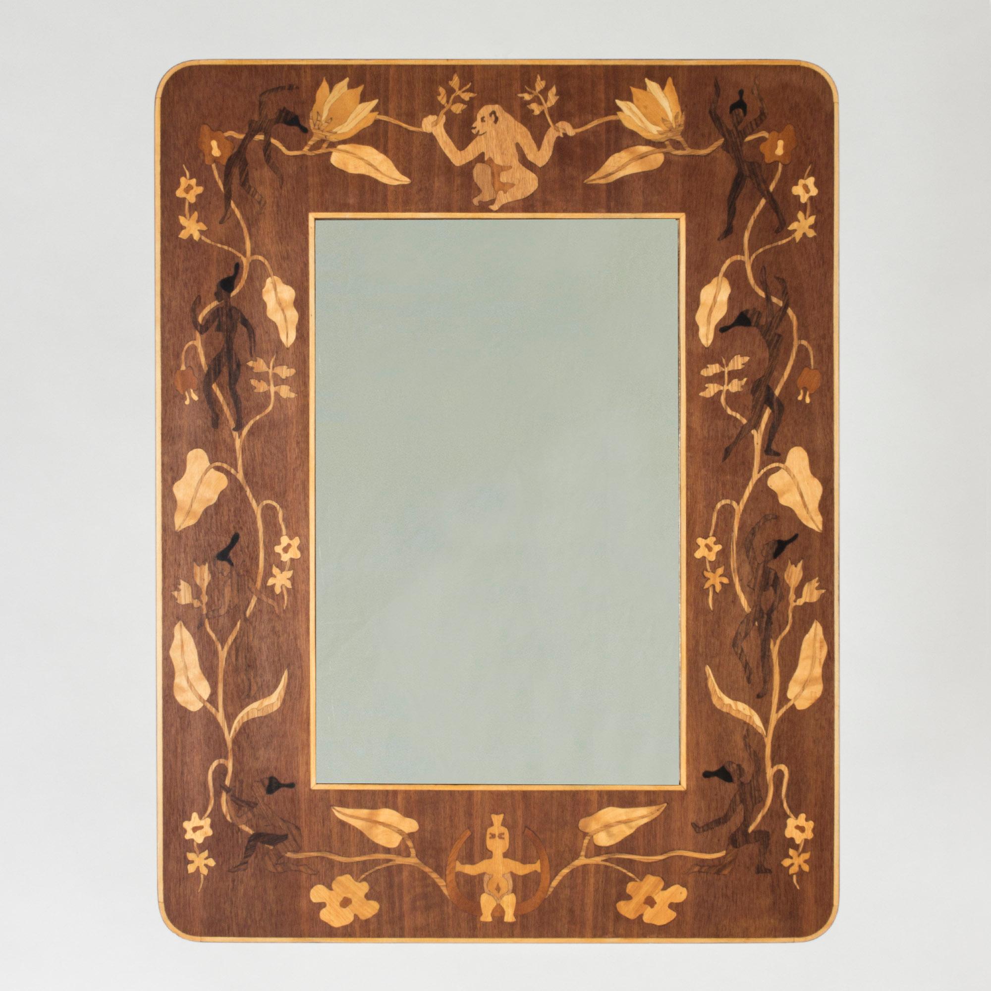 Beautiful wooden mirror from Bohus Intarsia with a motif called “Adoration”. Inlays of contrasting wood depict flowers and leaves, interlacing with women, a monkey and a whimsical character at the bottom. The types of wood used are listed on the